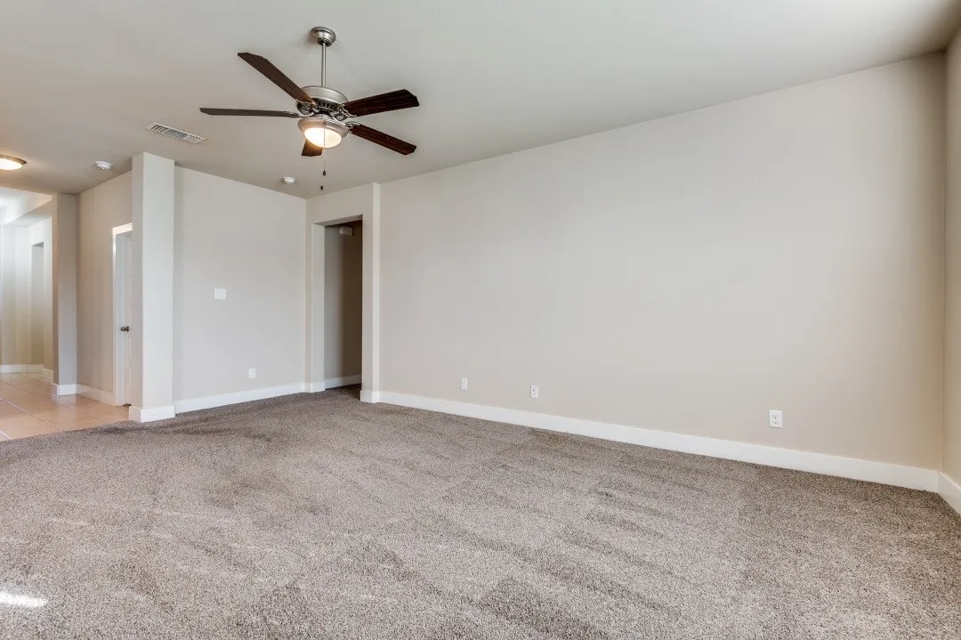 Expansive room featuring neutral wall paint and plush carpeting