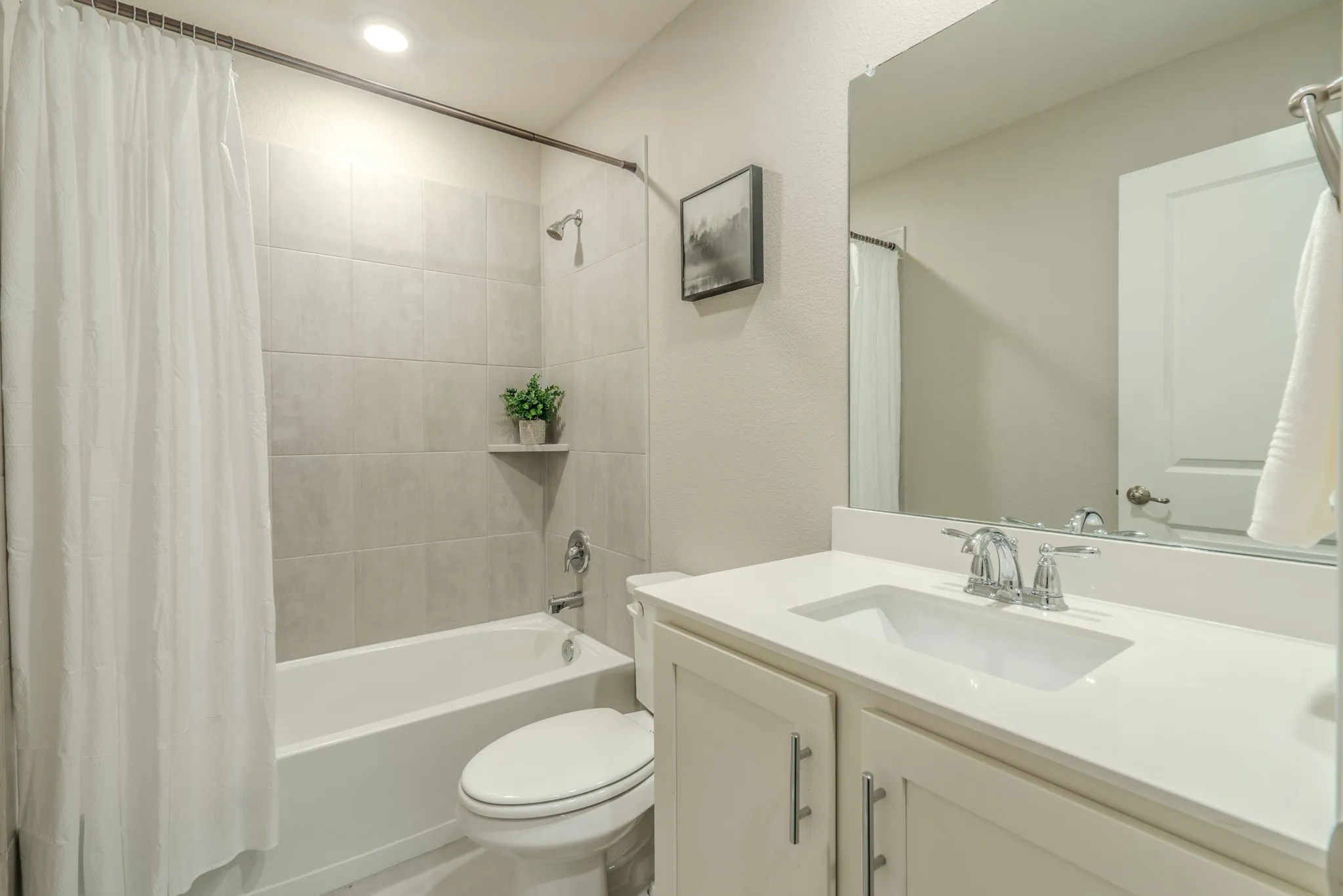7329 Allium Court, Little Elm, TX 76227 - bathroom - Bathtub with tiled surround, single vanity with integrated sink, and chrome fixtures