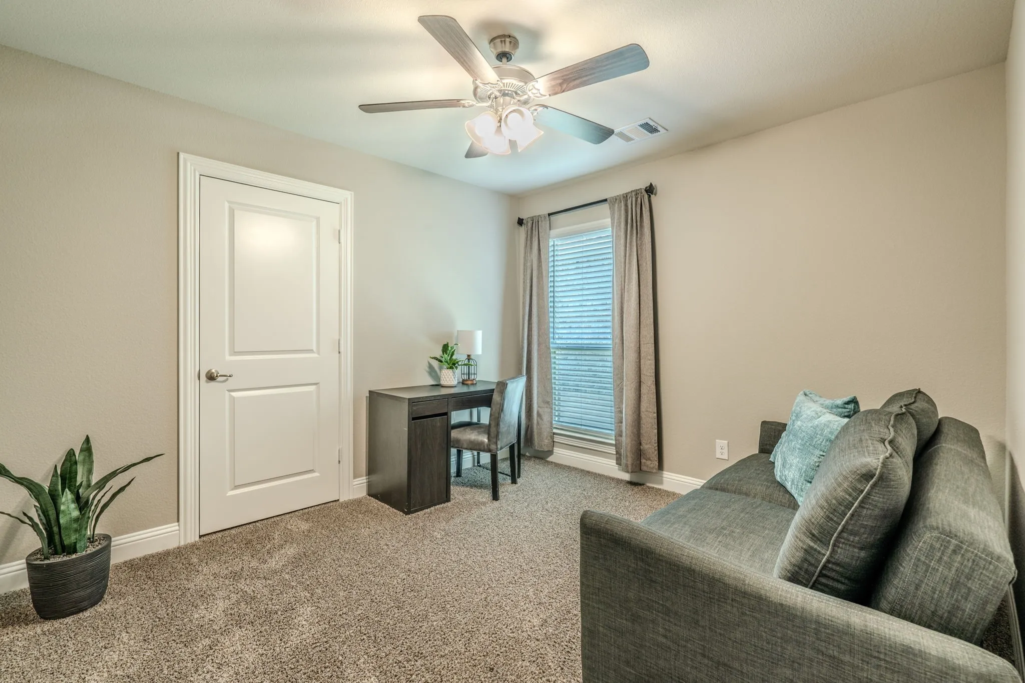 Window with blinds and drapes, ceiling fan with light fixture, light gray wall paint, white trim, and carpet flooring