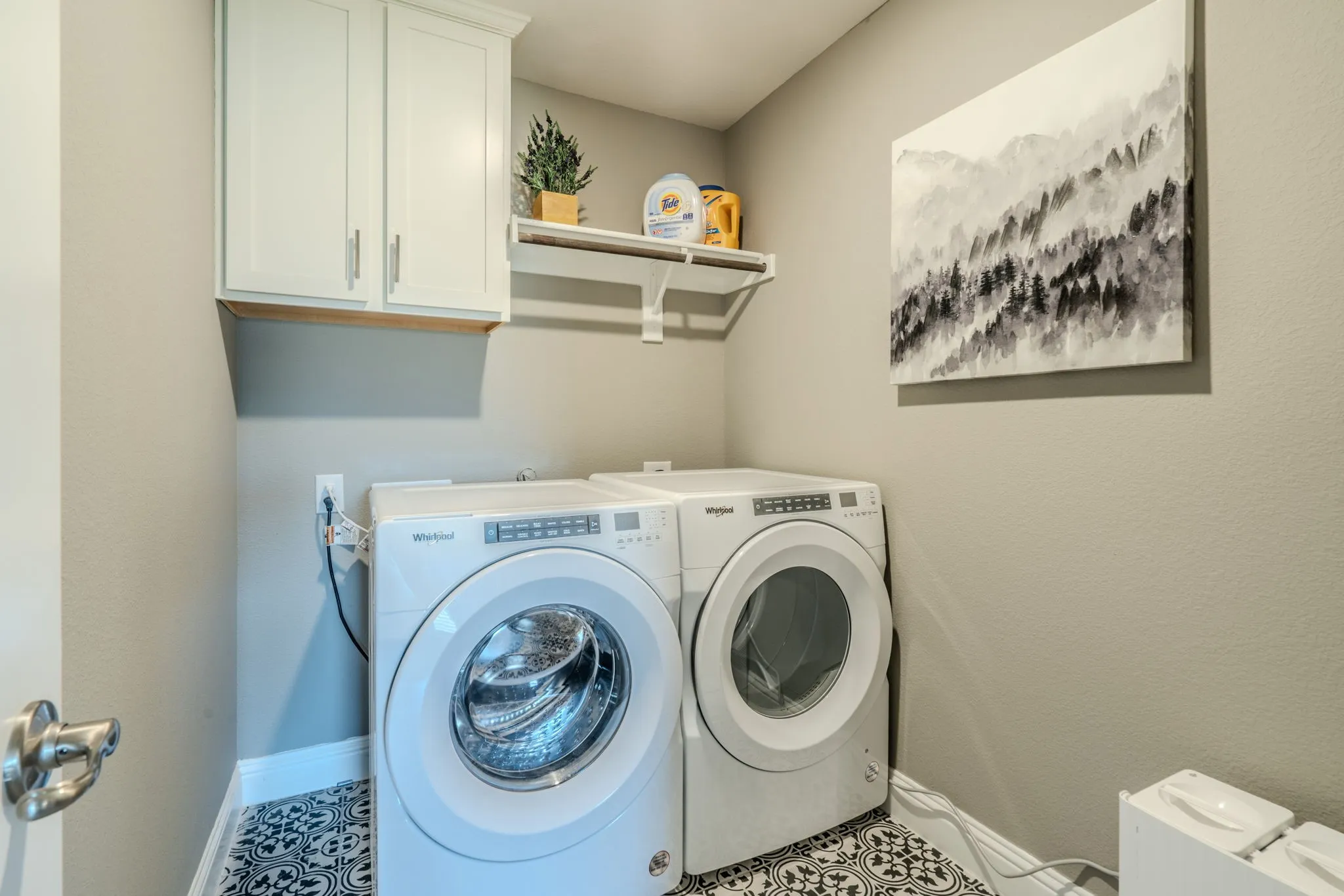 7329 Allium Court, Little Elm, TX 76227 -laundry - Laundry area featuring white cabinetry, a floating shelf, and patterned floor tile