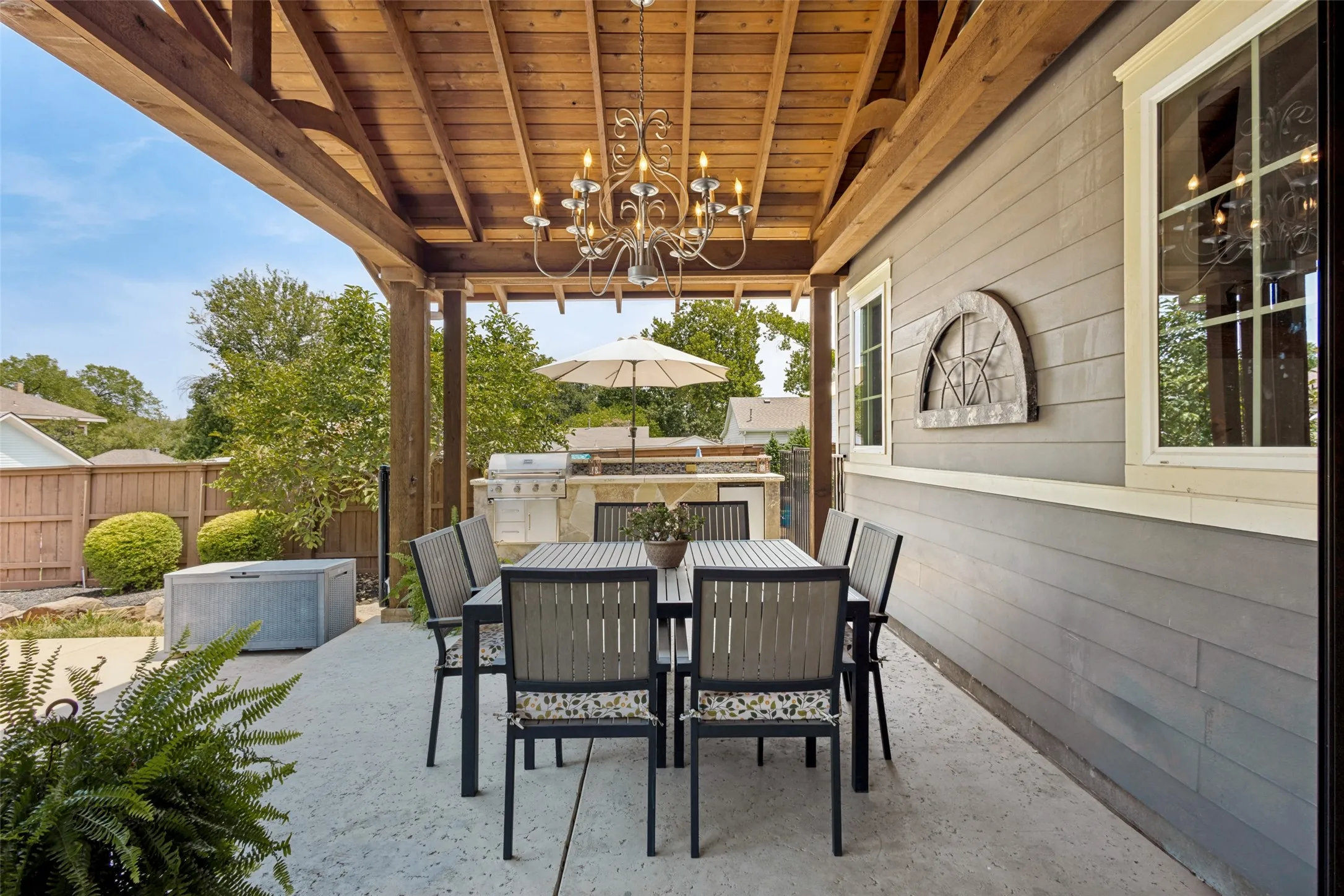 Covered patio featuring a wood-plank ceiling, exposed wood beams, and a built-in outdoor kitchen