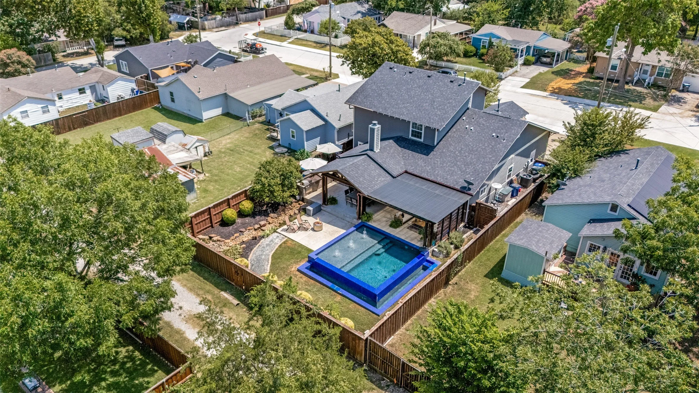 Outdoor living space featuring a covered patio, an elevated swimming pool, and a fenced backyard