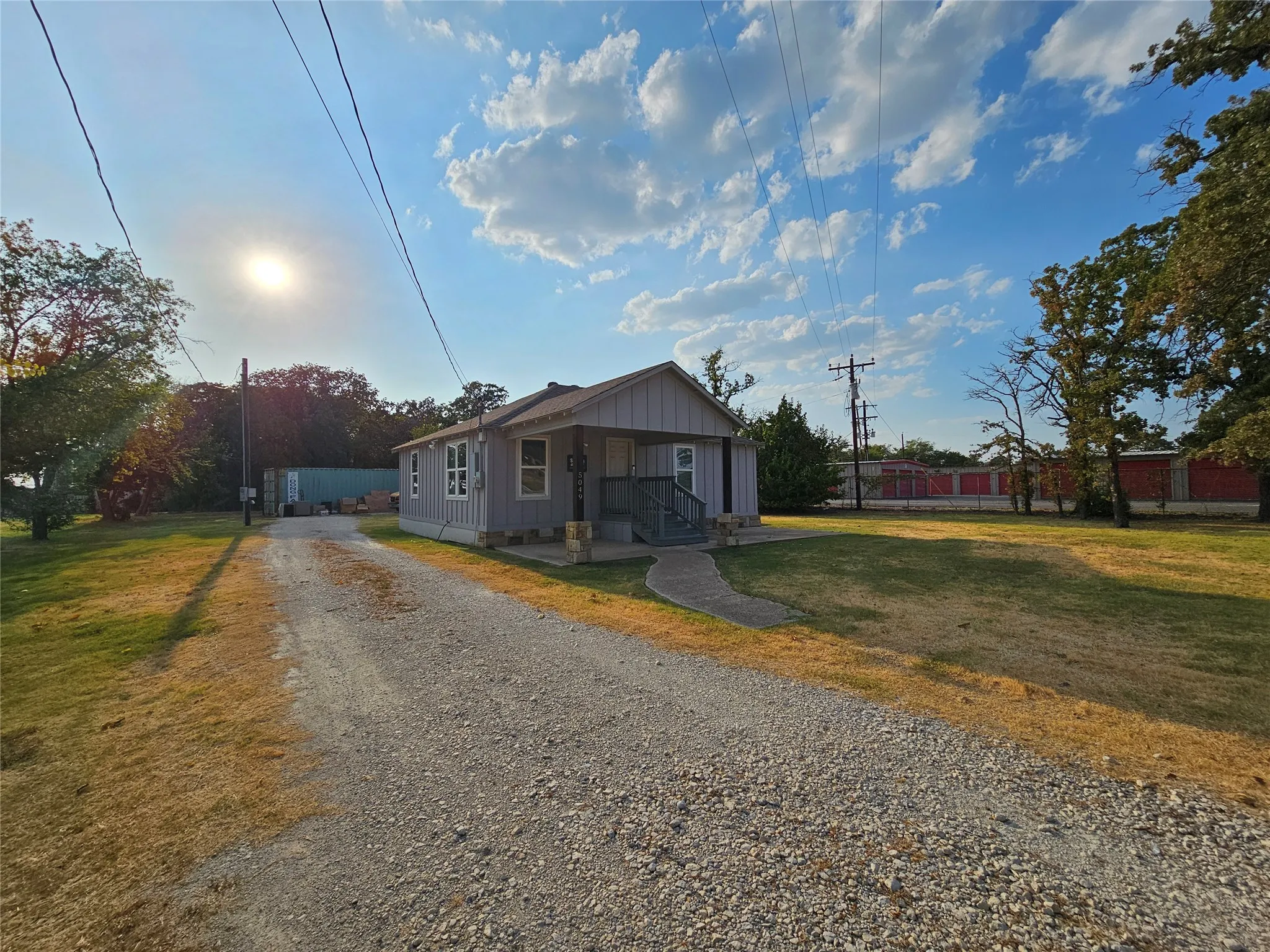 Single-story office featuring light gray siding and a covered front porch