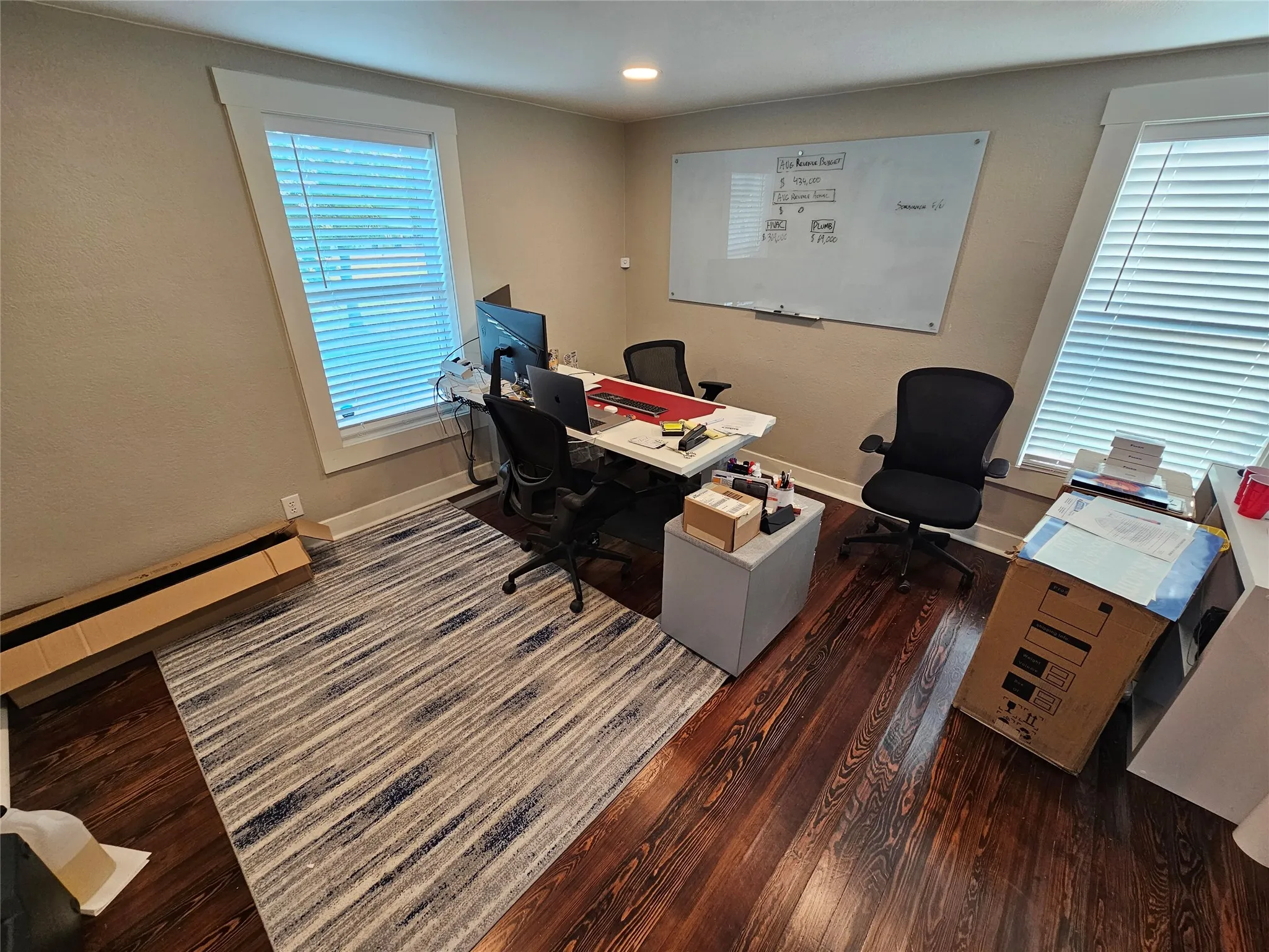 Room featuring rich wood-finish flooring, light-toned walls, and white trim work