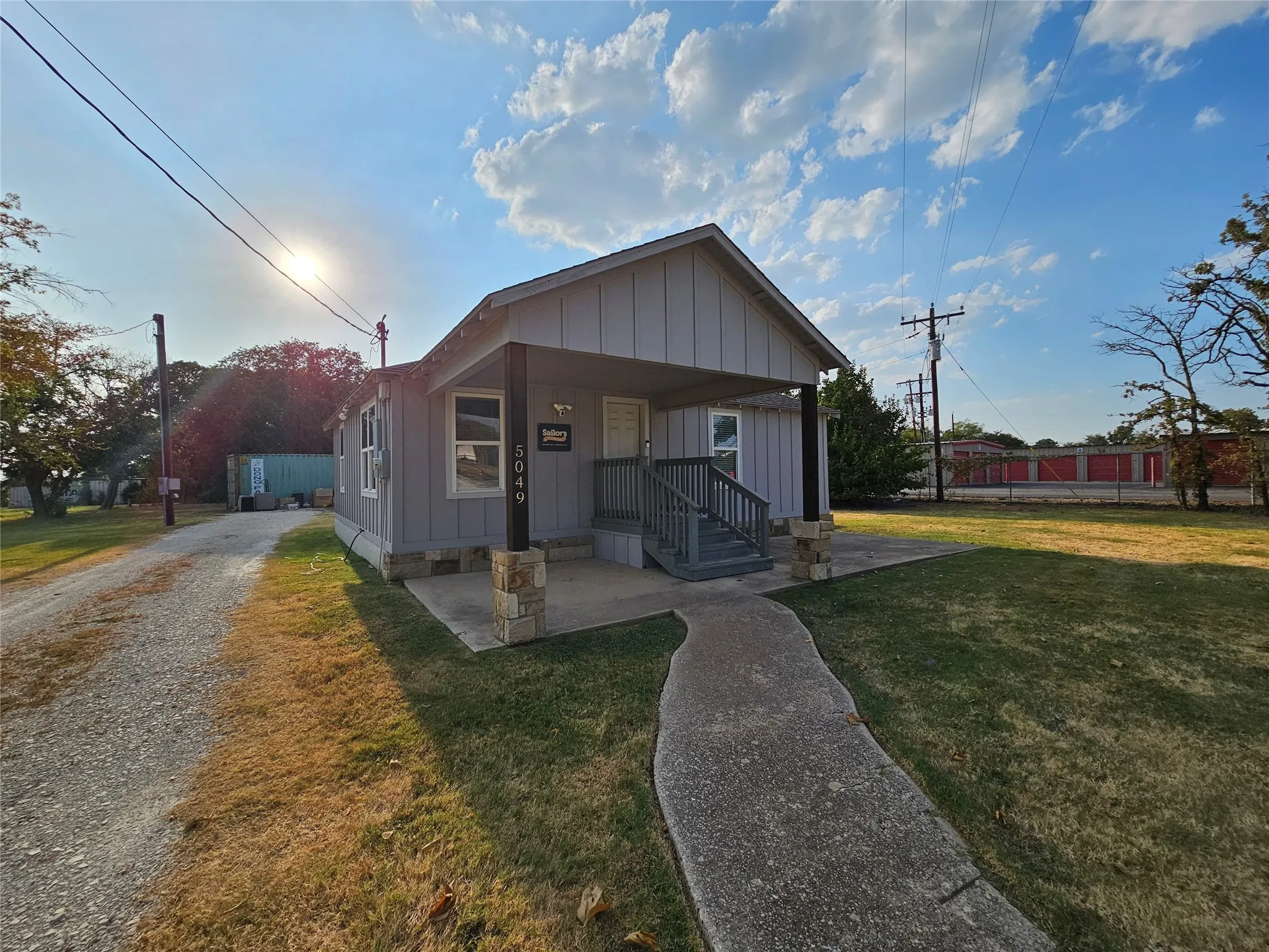 Single-story exterior with light gray siding and white trim