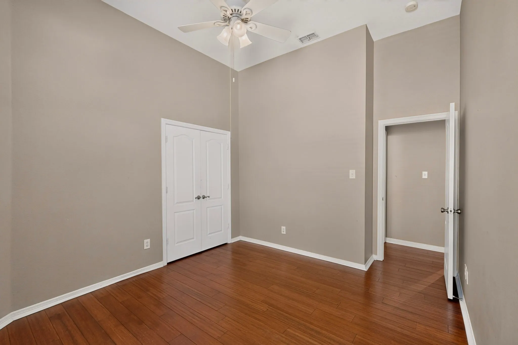 Vaulted ceilings, wood-finish flooring, ceiling fan, and double-panel doors