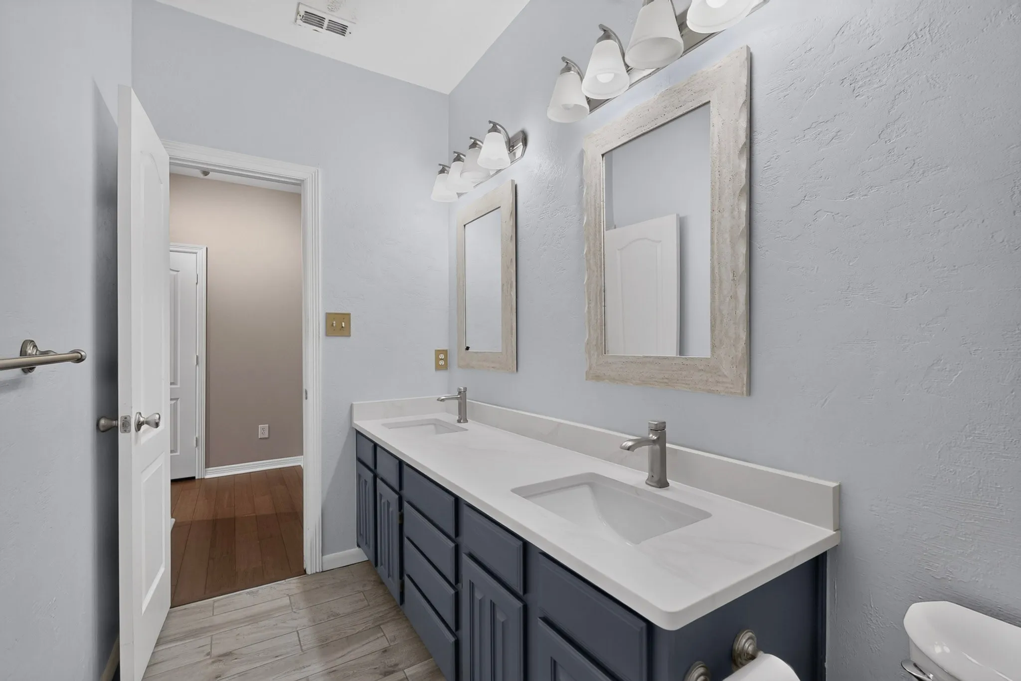 Dual vanity with integrated sinks, white countertops, and brushed nickel fixtures