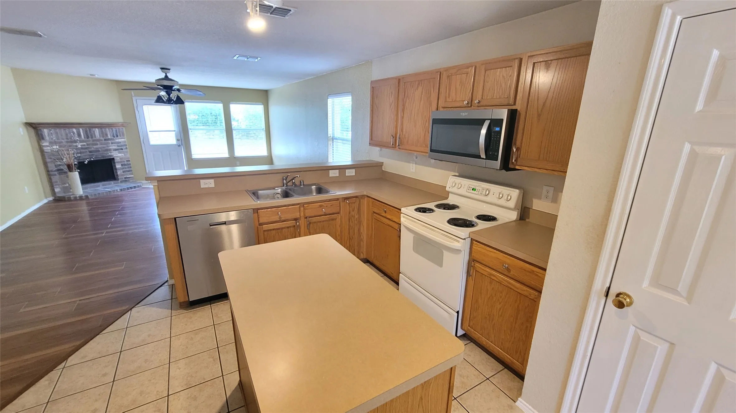 Kitchen featuring wood cabinetry, stainless steel dishwasher, and an island with counter space
