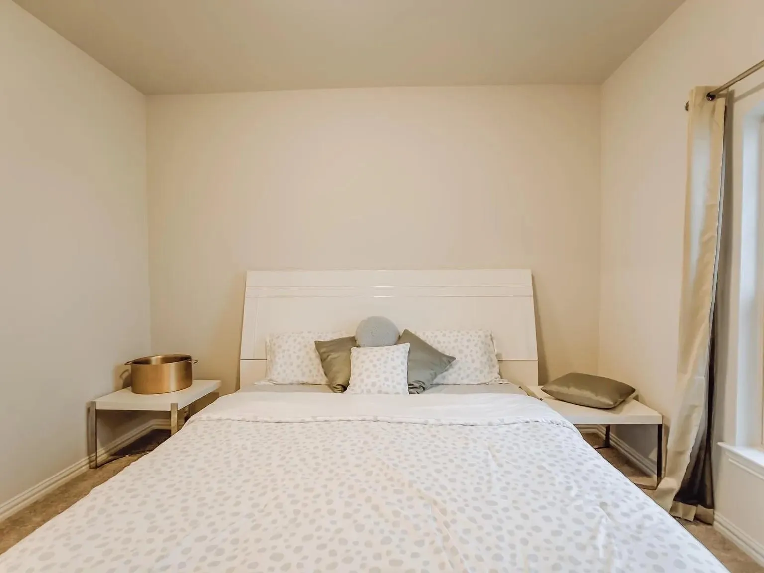 Neutral wall color, window with curtain rod, and carpeted flooring