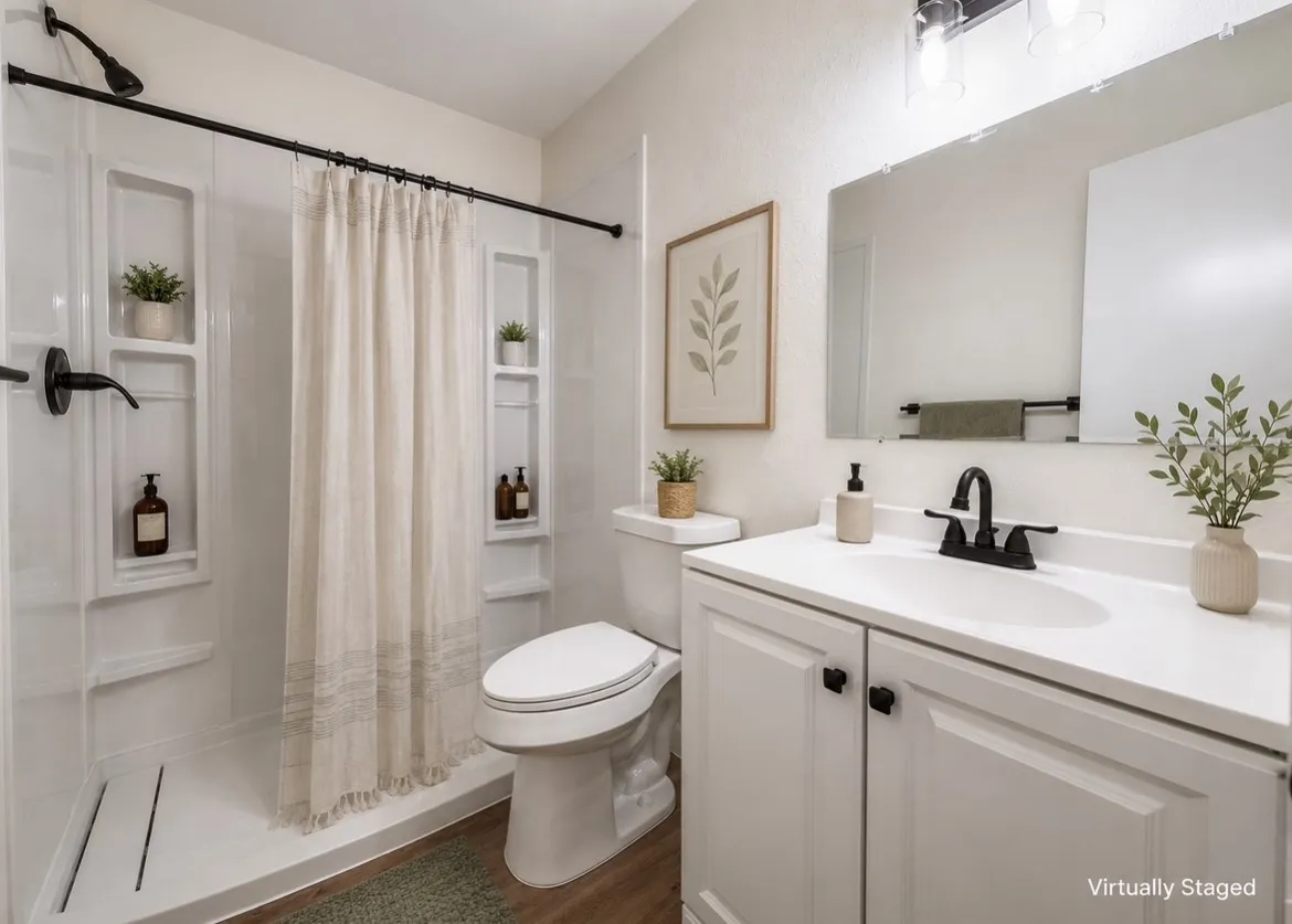 Bathroom featuring a shower with built-in shelving, a white vanity with a single basin sink, matte black fixtures, and wood-finish flooring