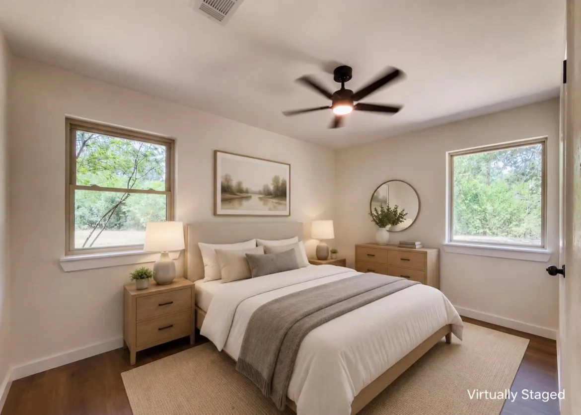 Bright room featuring wood-finish flooring, two large windows, a ceiling fan with integrated lighting, and neutral wall tones