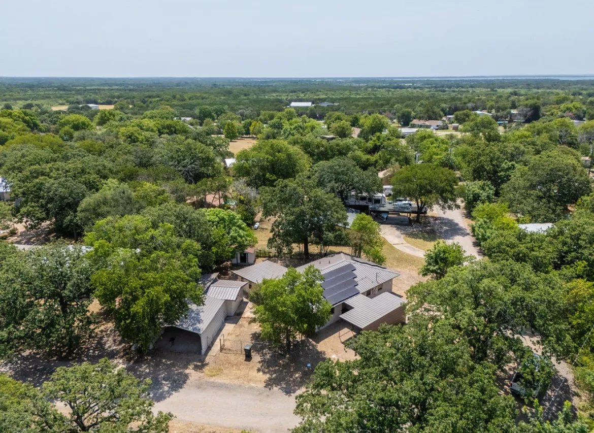 Aerial perspective showcasing a property surrounded by mature trees