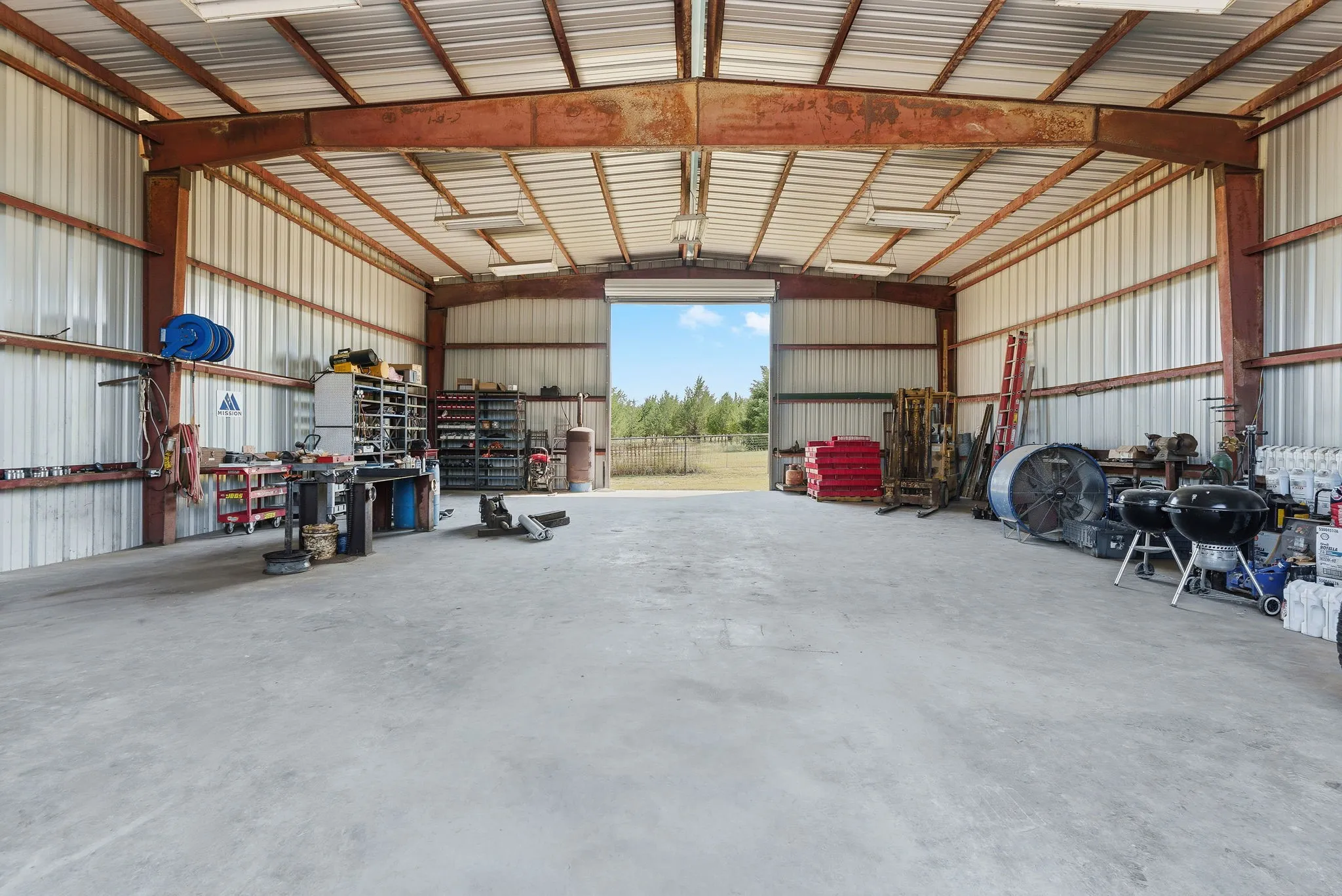 Two roll-up doors on opposite ends provide convenient access to the workshop’s expansive open interior, with ample room to organize tools, store recreational gear, and bring your next big project to life.