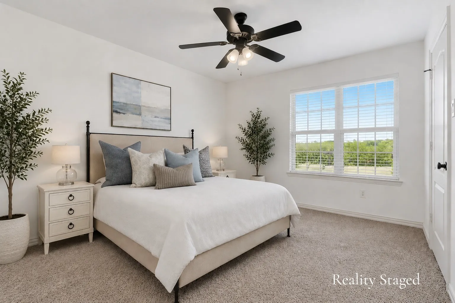 This inviting upstairs bedroom offers the comfort of a private en suite bath, with a wide window welcoming natural light and framing relaxing views of the surrounding countryside. Soft carpeting and a neutral palette create a restful retreat, perfect for hosting overnight guests or enjoying a quiet space of your own.