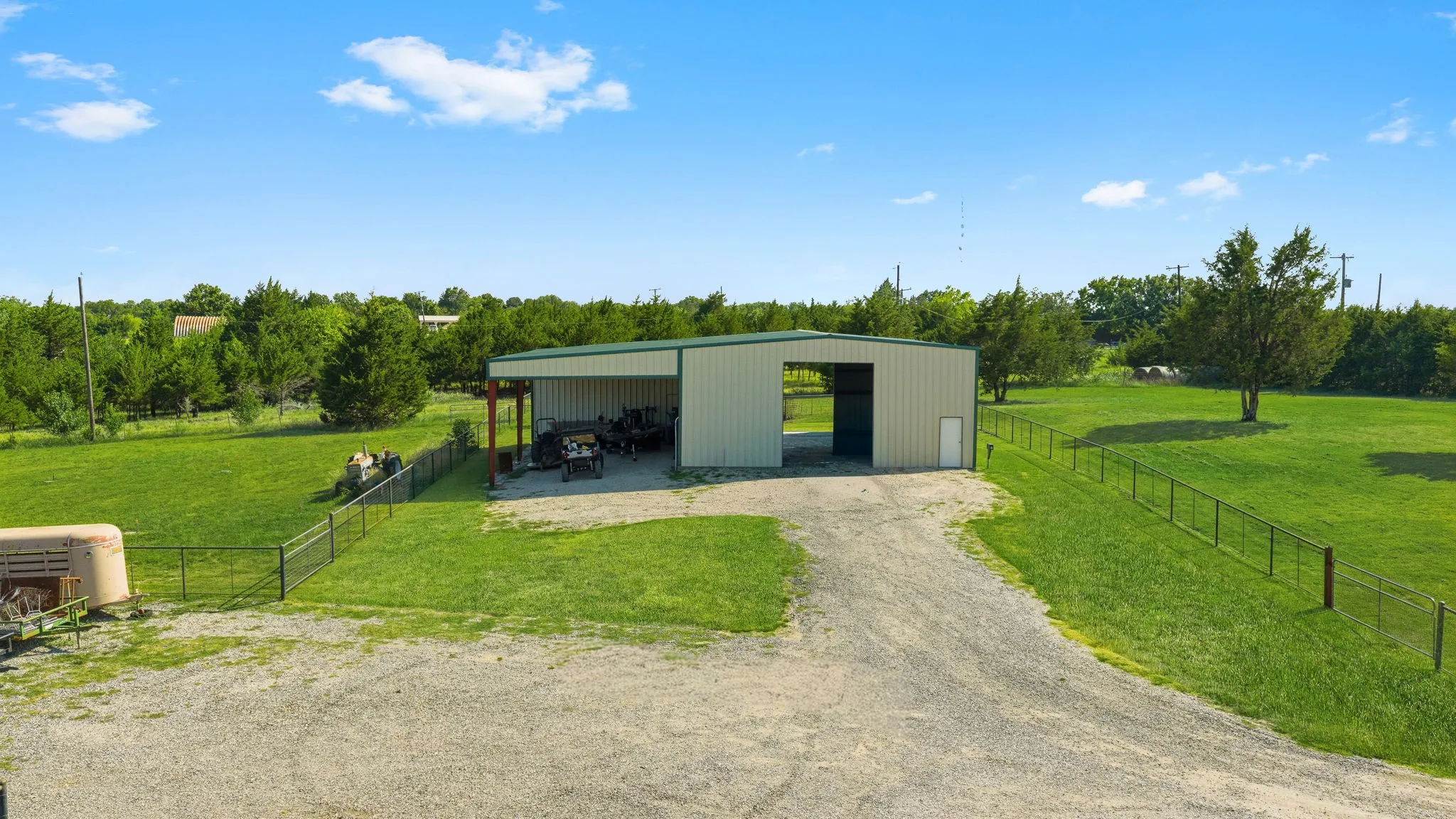 The 40-by-50-foot workshop offers drive-through access, a 25-by-50-foot covered awning, and a 10-by-25-foot storage area at the back of the awning accessible from inside the workshop, providing generous space for projects, equipment, and organized storage.
