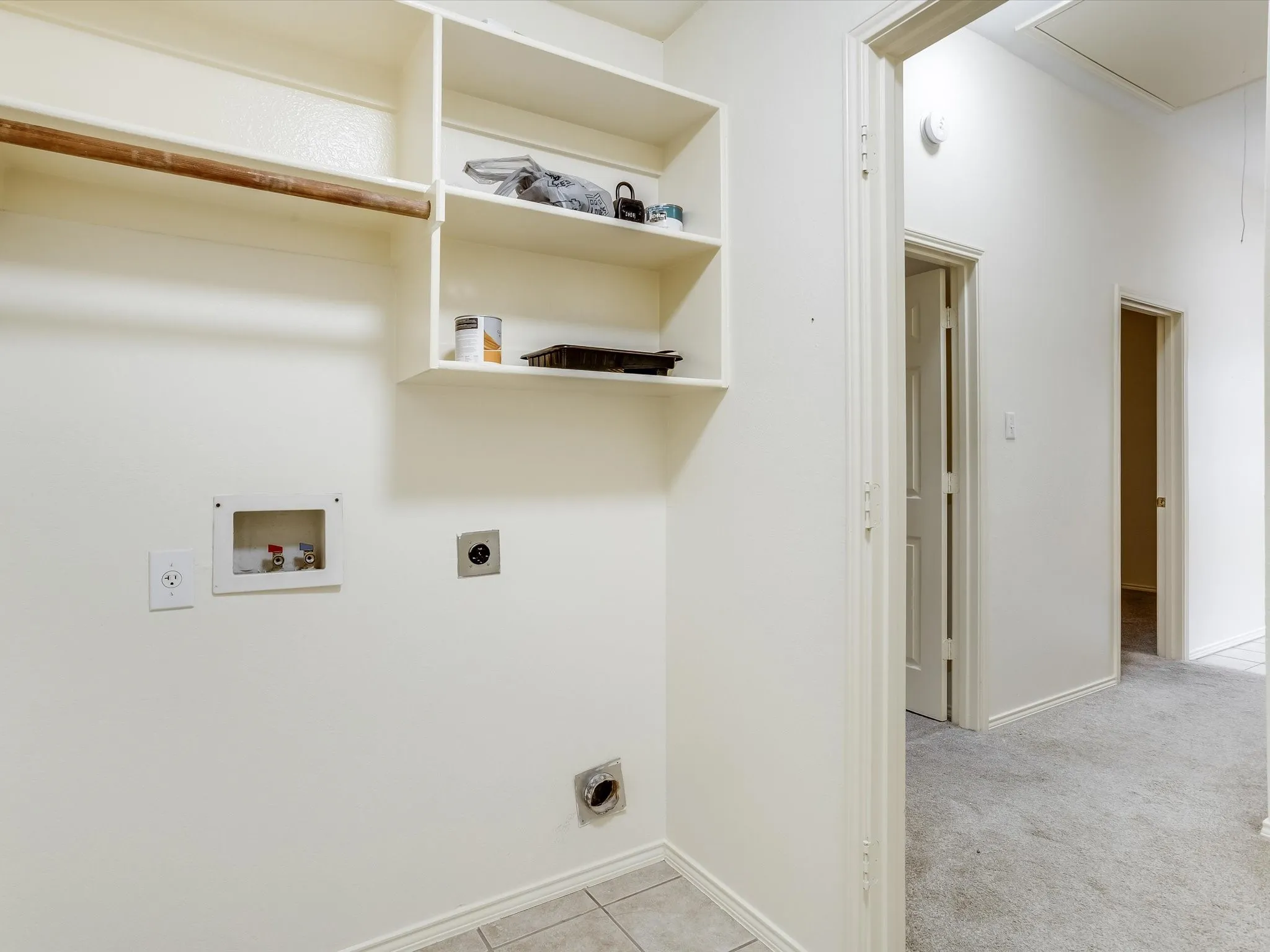 Laundry and utility space featuring custom built-in shelving with wood-finish trim, recessed lighting, and multiple electrical outlets and HVAC ports