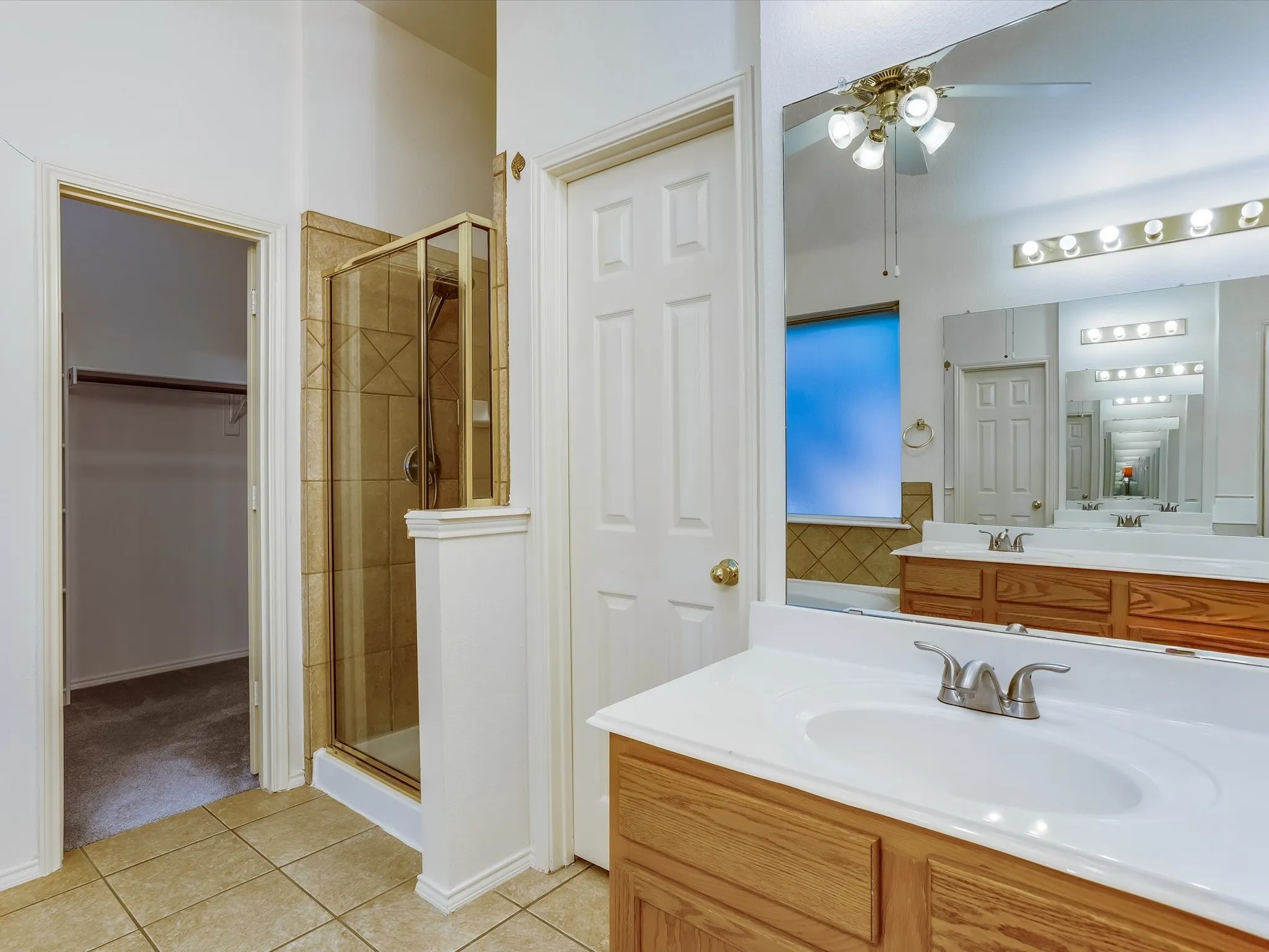 Bathroom vanity featuring dual sinks with integrated white countertops and brushed nickel fixtures