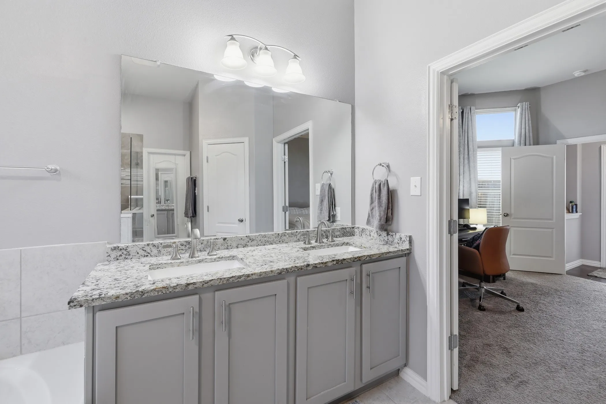 Double vanity featuring granite countertops with dual sinks