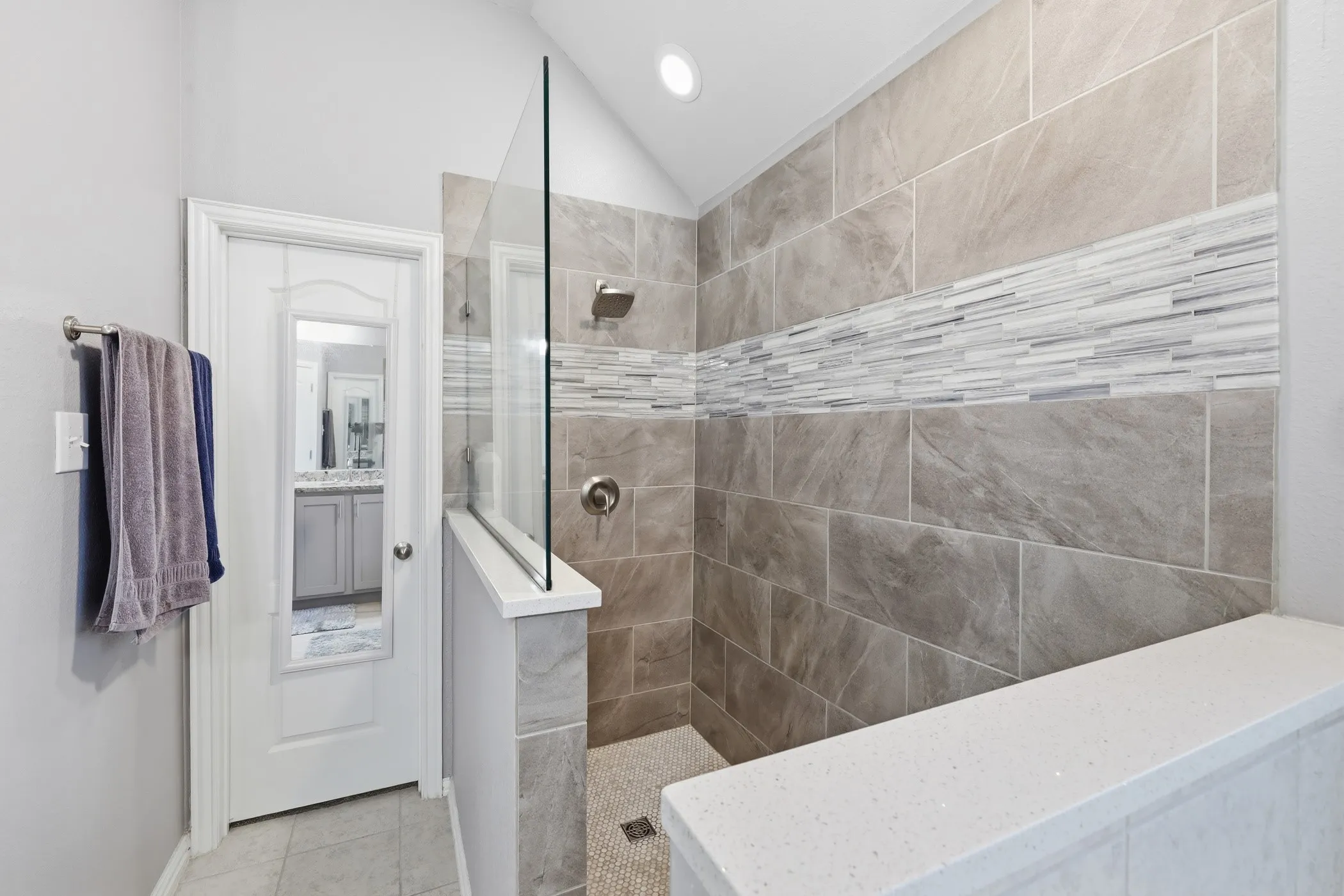Walk-in shower featuring a frameless glass panel