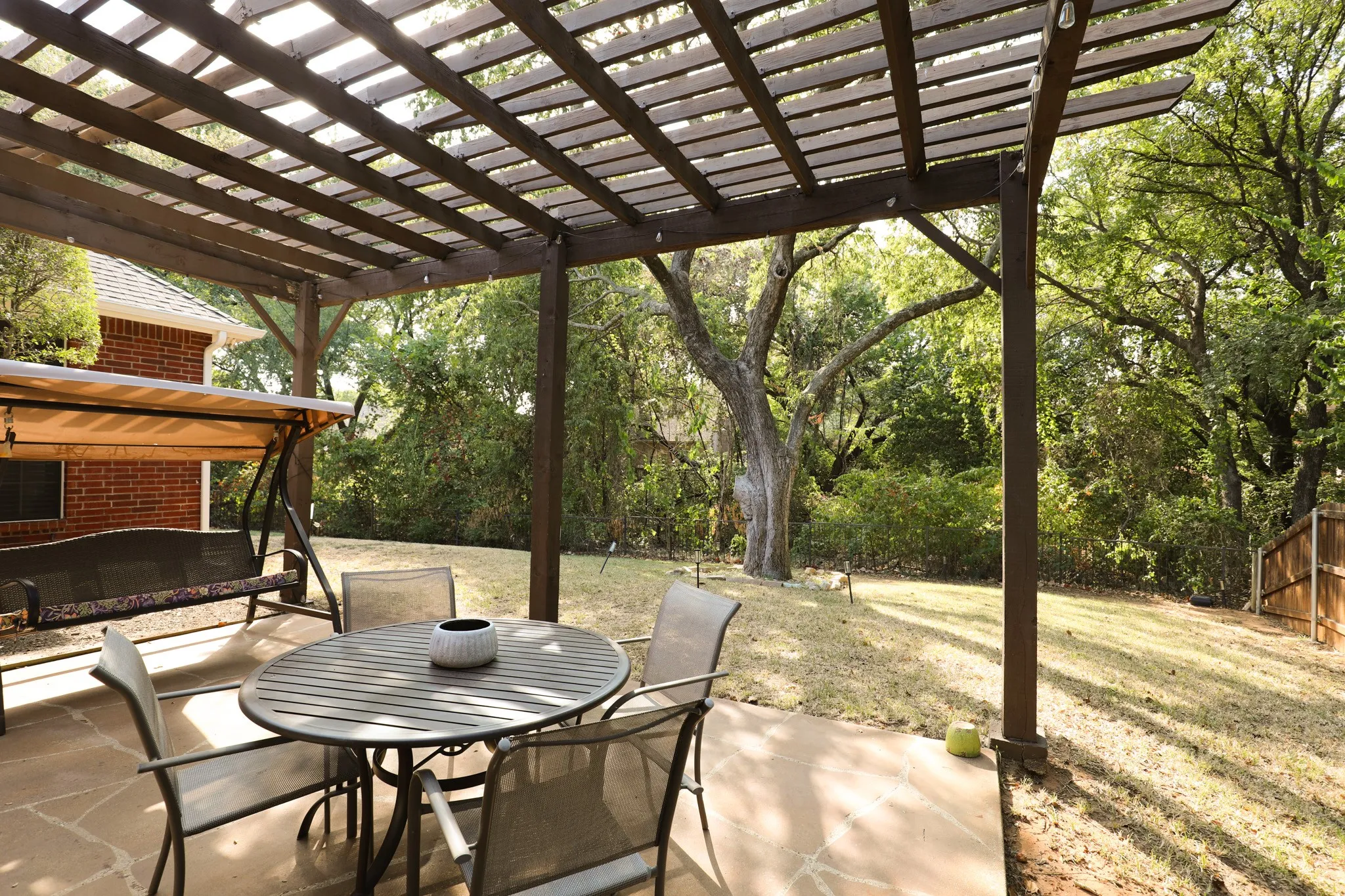 Expansive backyard featuring a wood pergola and a paved patio
