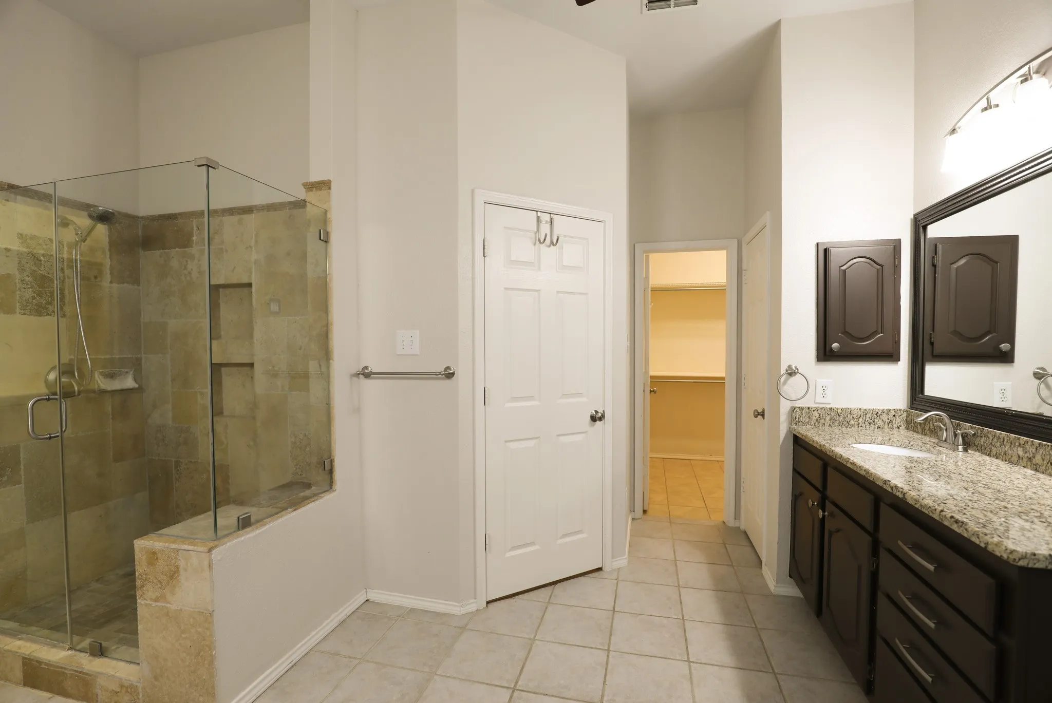 Glass-enclosed shower with tiled walls and built-in niches