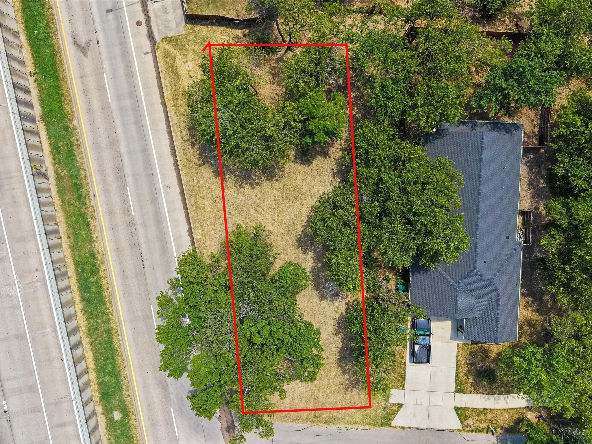 Aerial view of a rectangular lot with mature trees