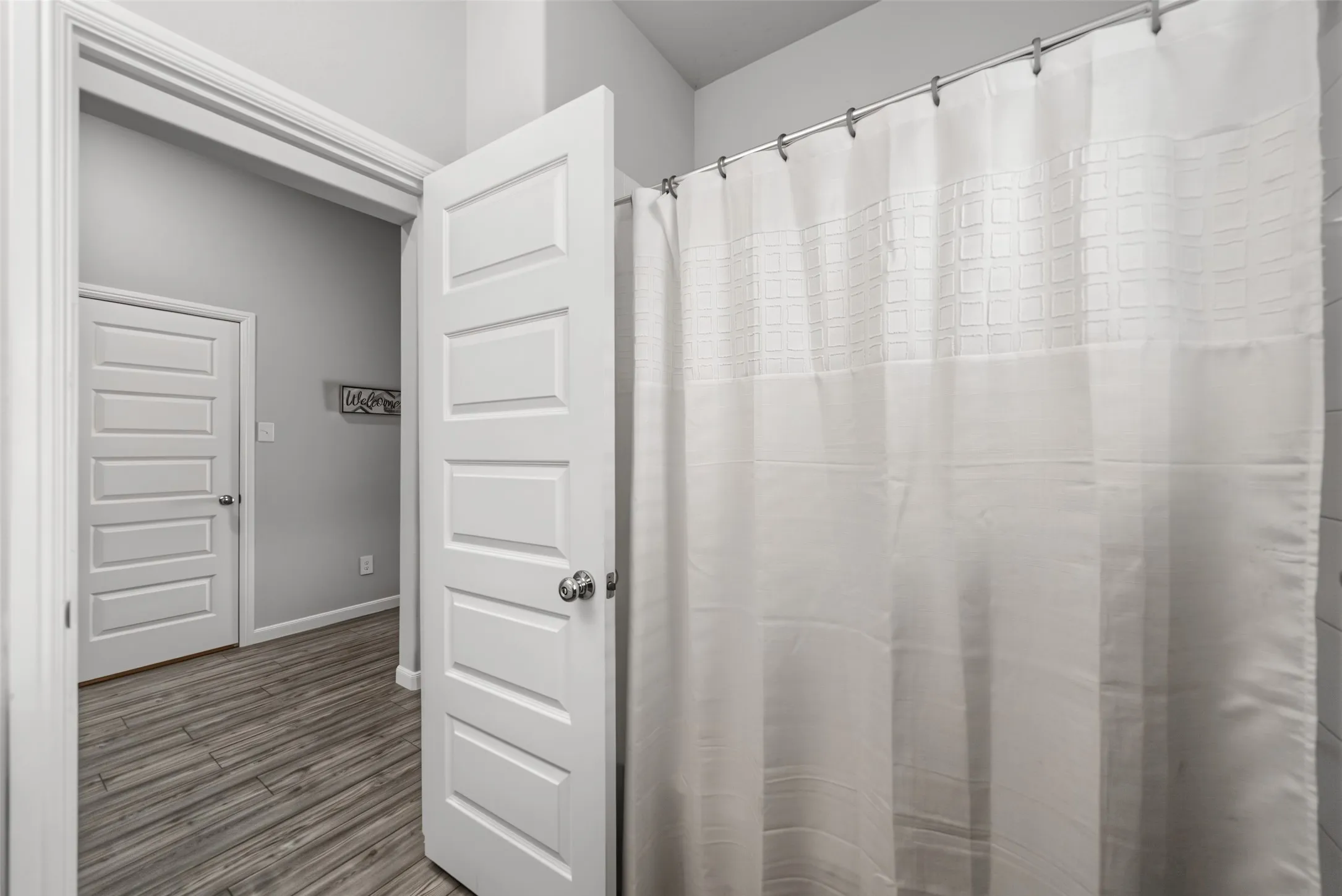 Wood-finish flooring, paneled interior doors, and light gray wall paint