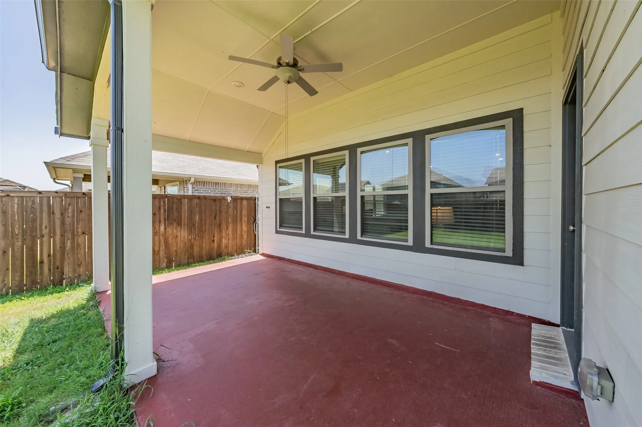 Covered patio featuring a ceiling fan, recessed lighting, and a red-toned concrete floor