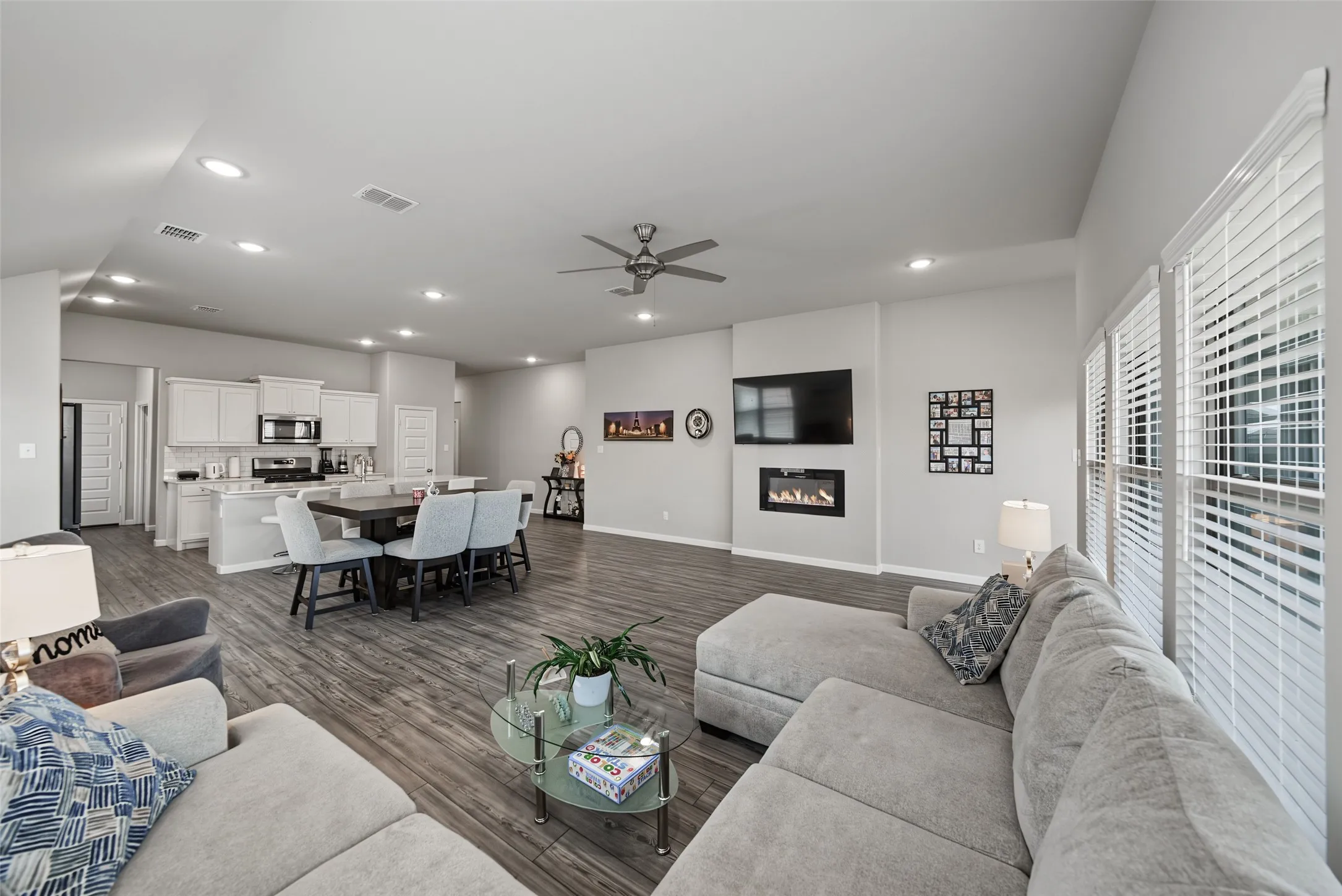 Open-concept living space with wood-finish flooring, recessed lighting, and a ceiling fan