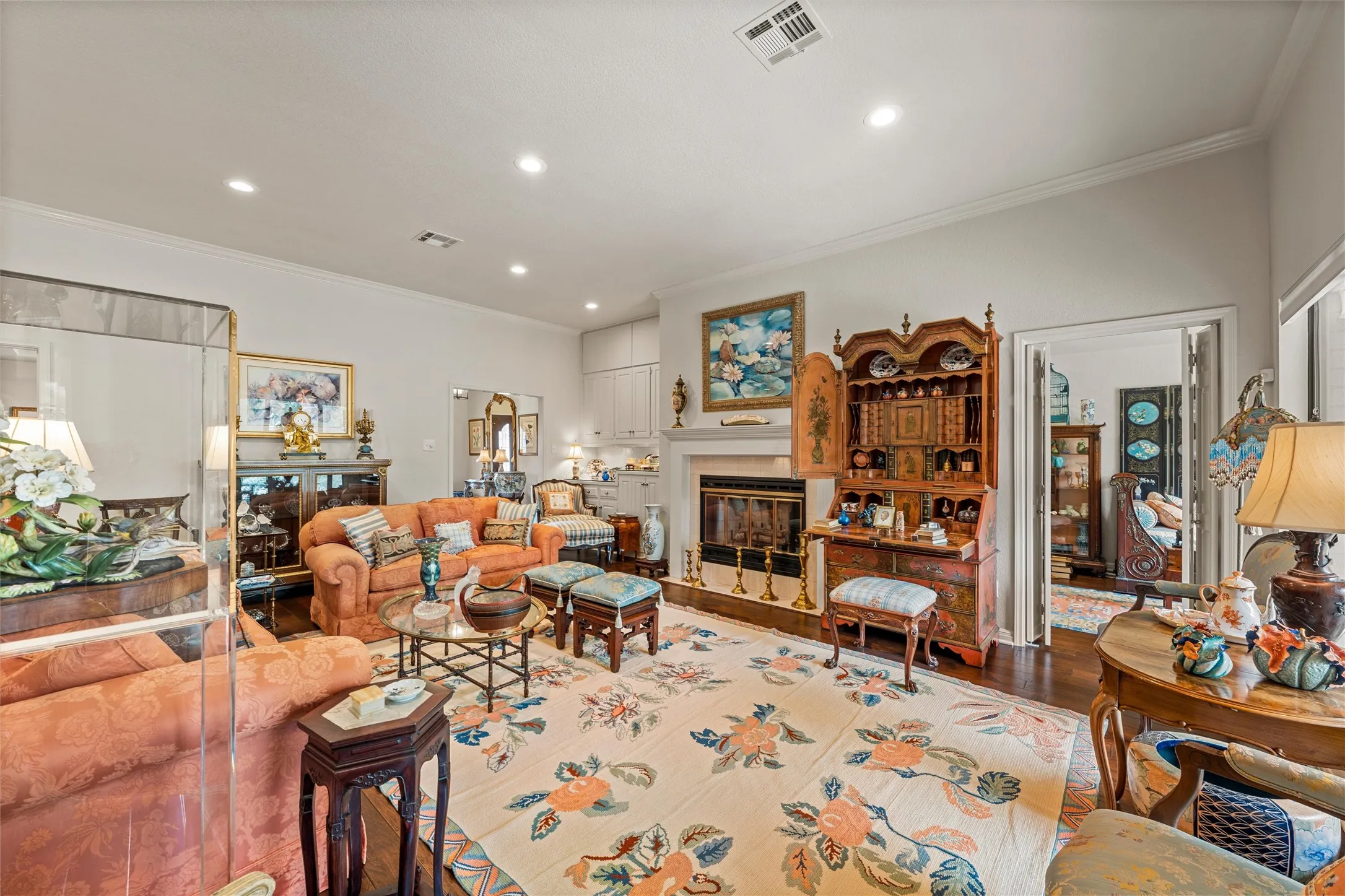 Spacious interior featuring wood-finish flooring, a decorative fireplace with a substantial mantel, and recessed ceiling lighting