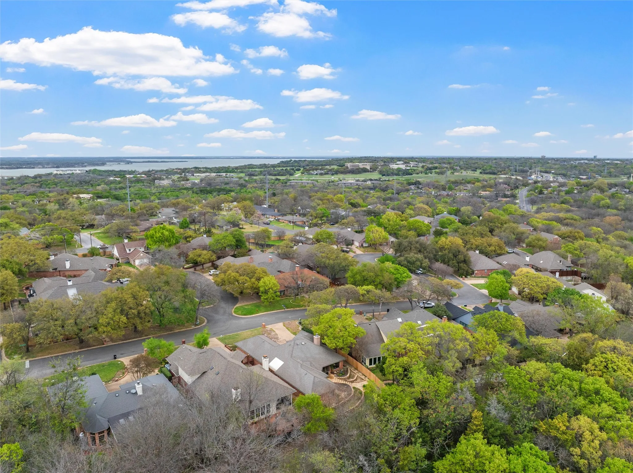 Aerial perspective showcasing a residential neighborhood with a dense tree canopy