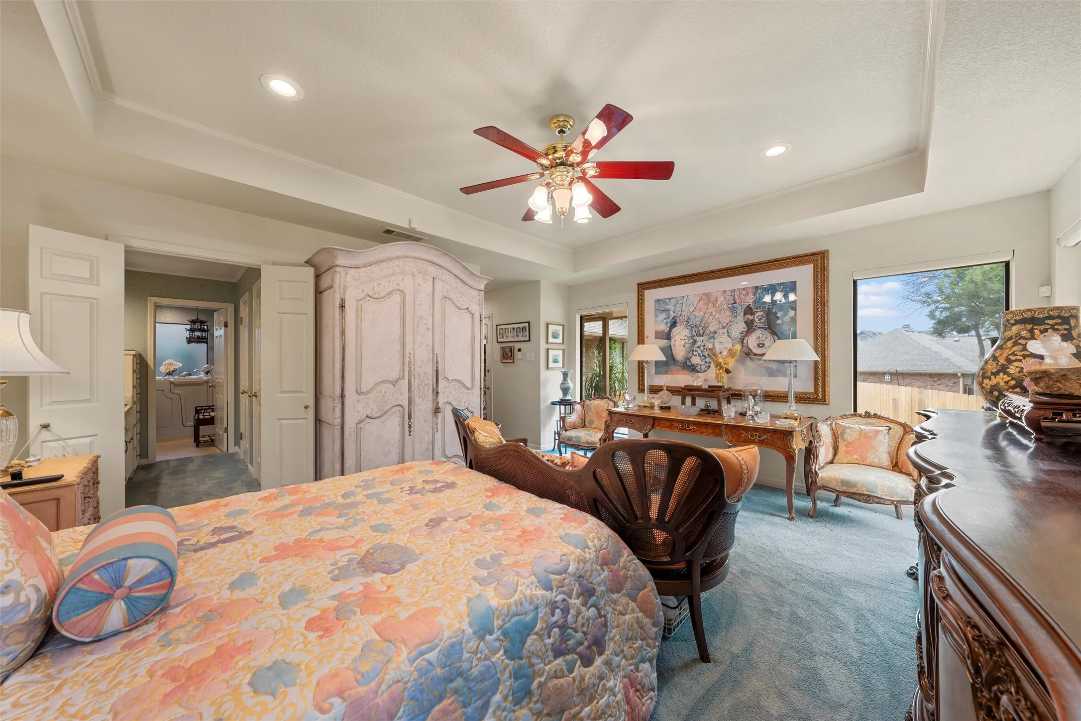 Spacious bedroom featuring a tray ceiling, recessed lighting, and a ceiling fan