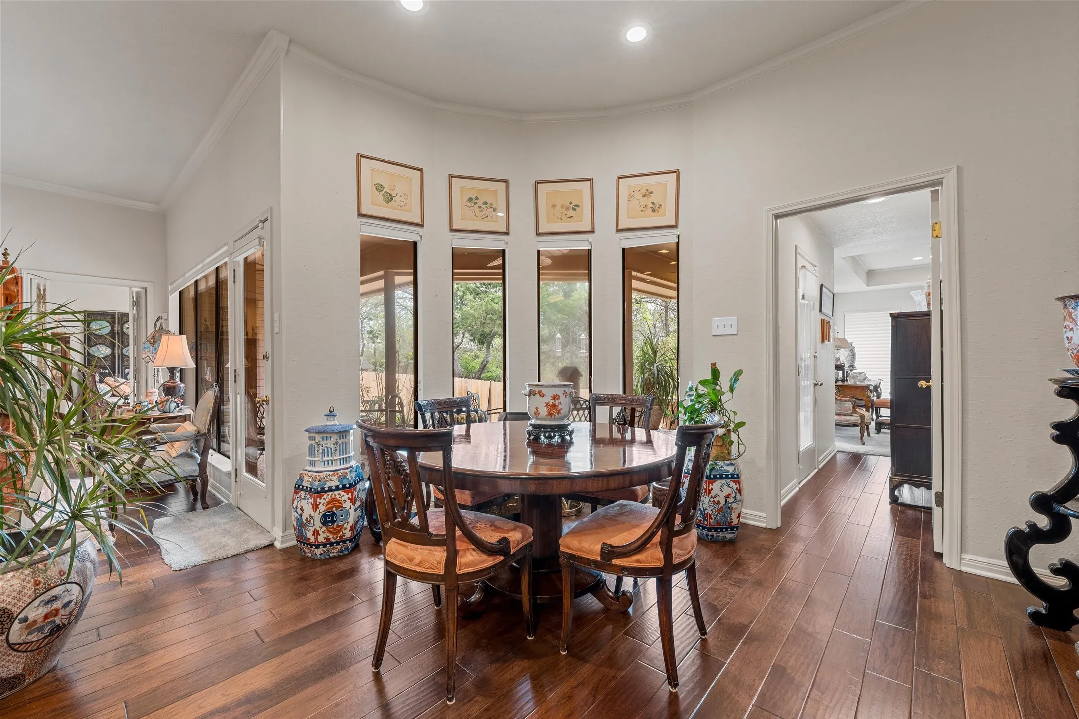 Dining area featuring wood-finish flooring and a curved wall with multiple windows