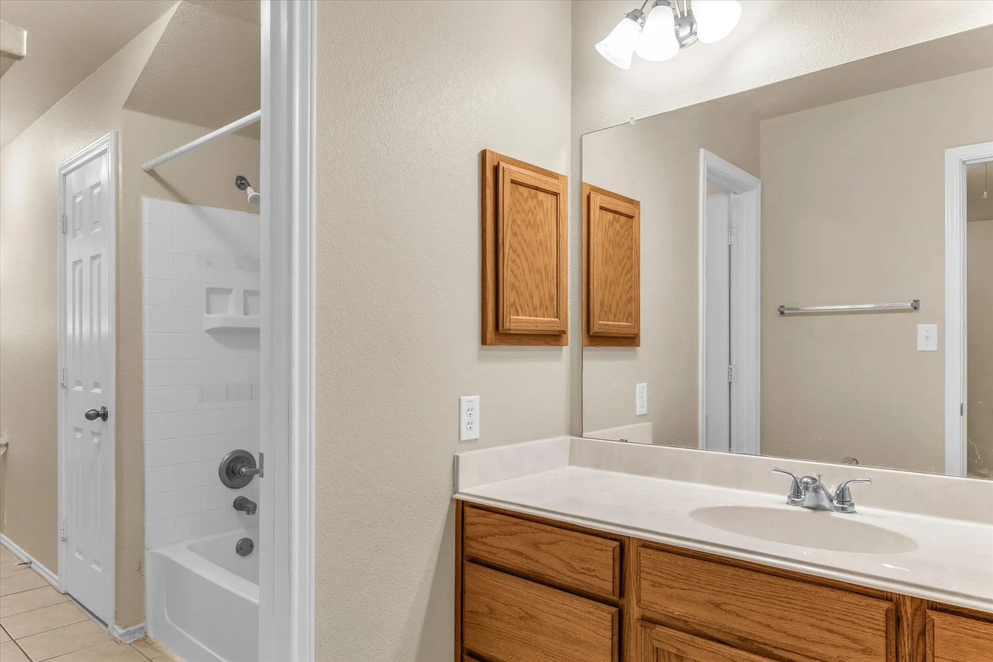 Bathroom featuring a spacious vanity with an integrated sink, polished chrome faucet, and ample under-sink storage