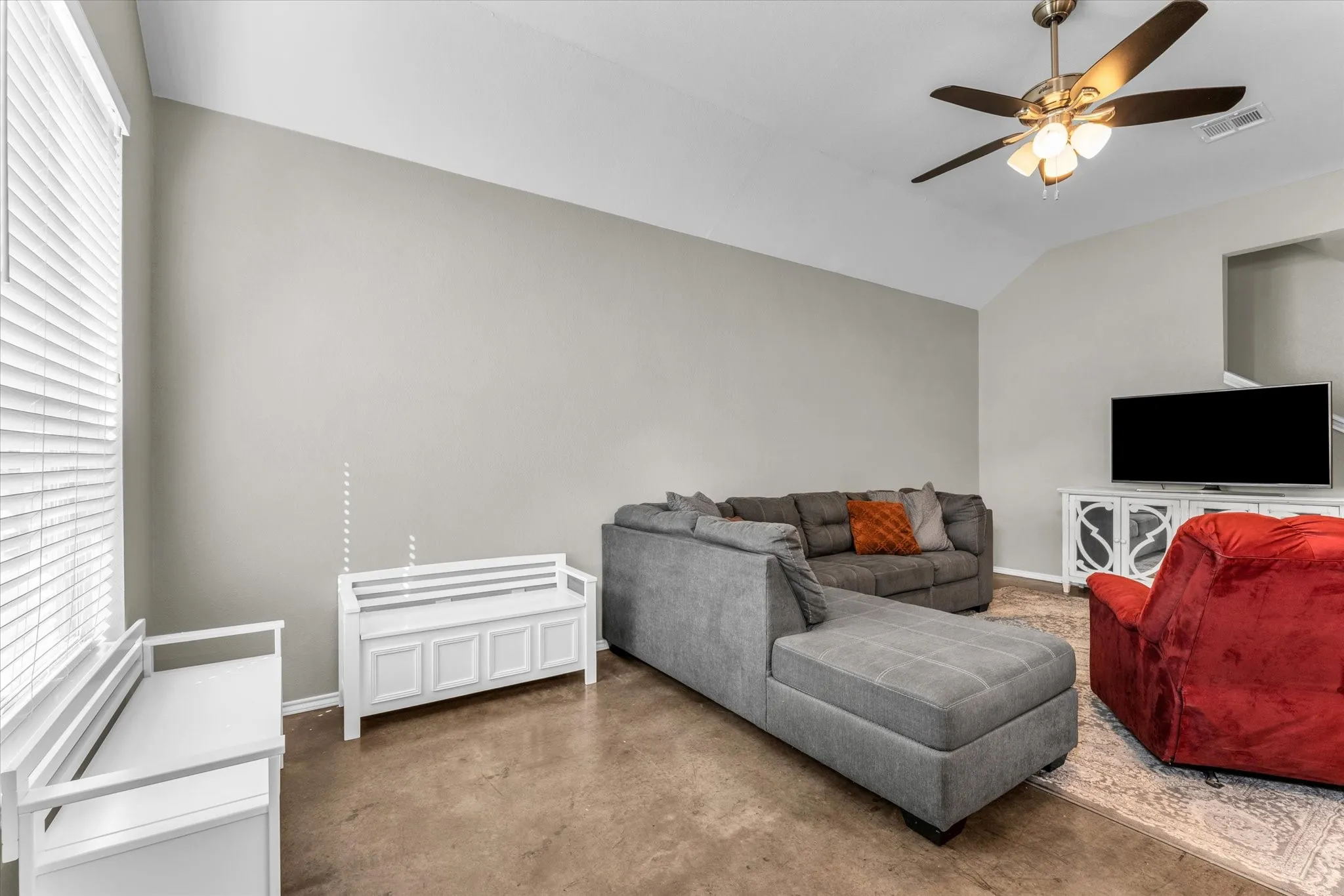 Versatile bedroom featuring neutral wall finishes, carpet flooring, and ceiling fan with integrated lighting