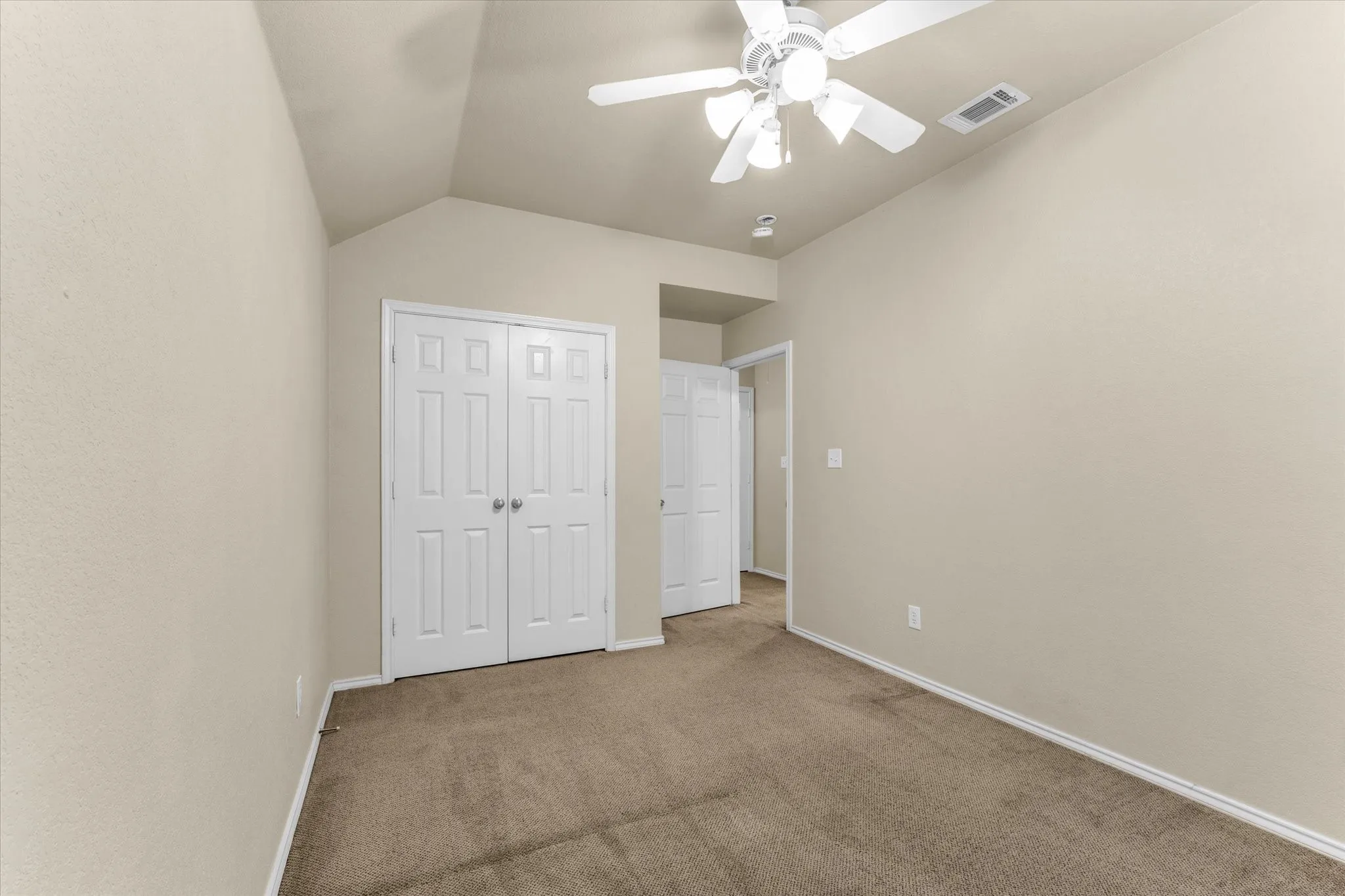 Room featuring vaulted ceilings, neutral-toned walls, and carpet flooring