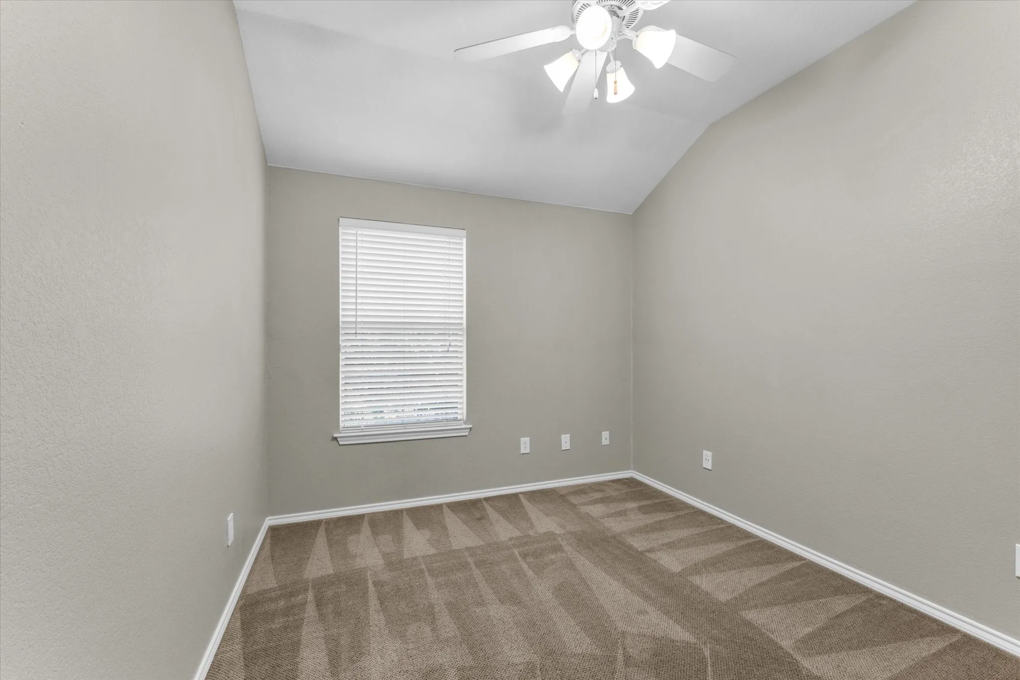 Room featuring a vaulted ceiling and textured walls