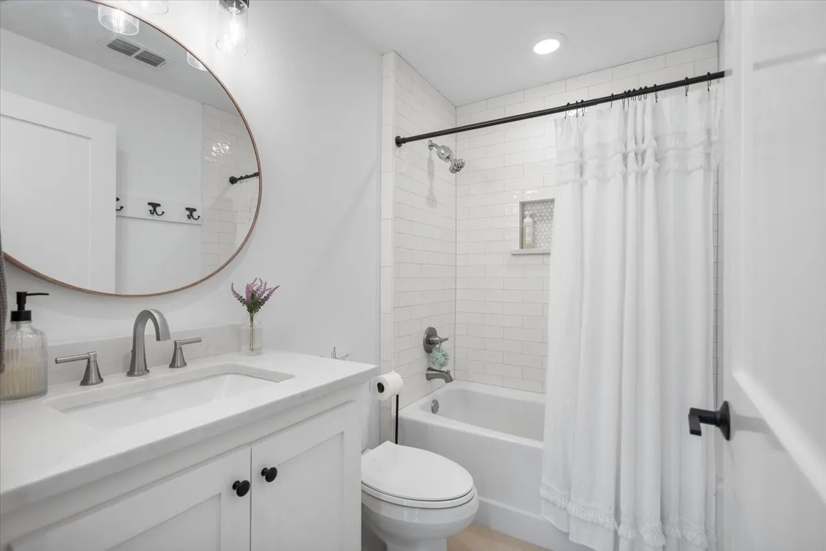 Bathroom featuring a white subway tile shower, built-in shower niche, and a white soaking tub