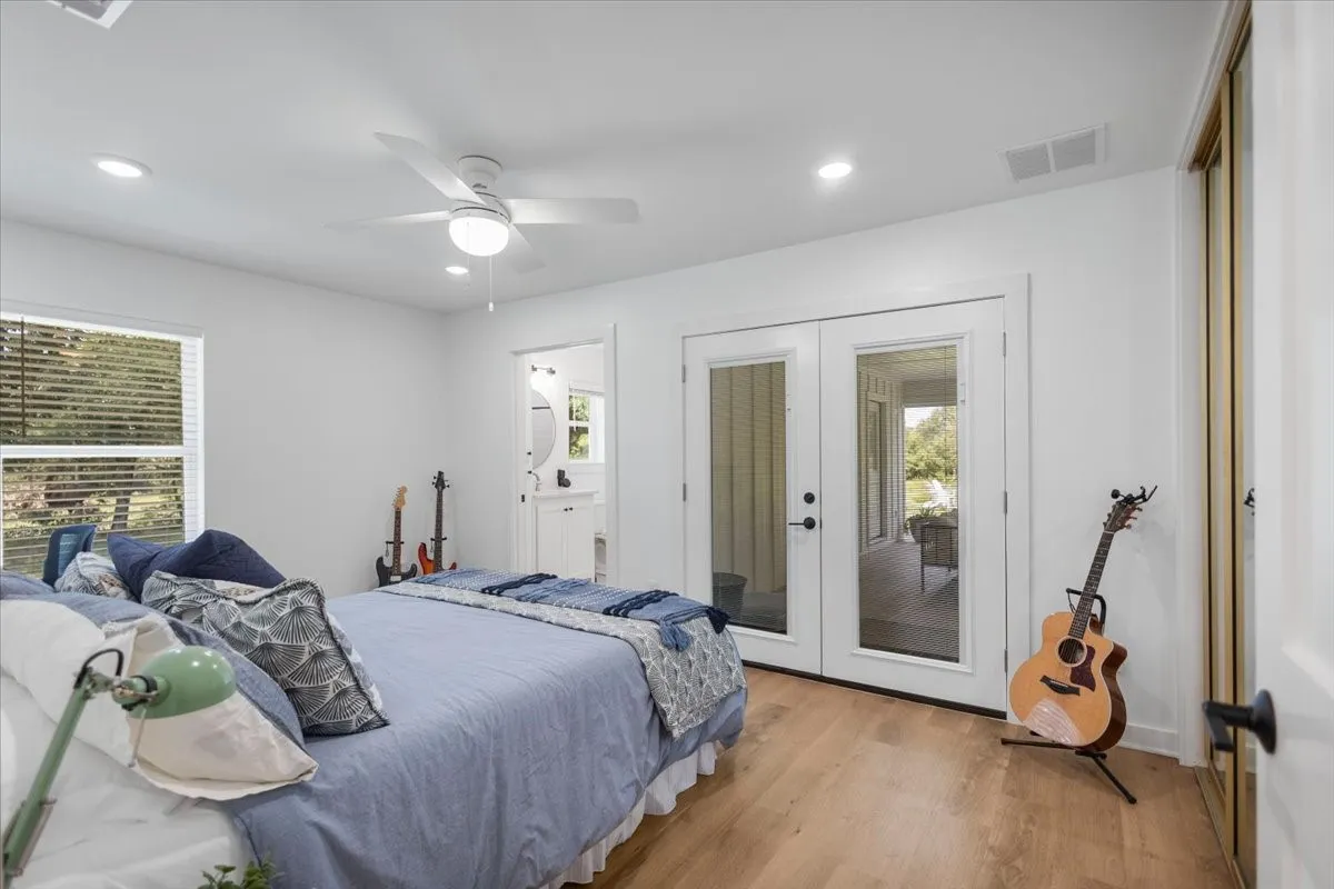Guest Bedroom with En Suite featuring light wood-finish flooring, white walls, and recessed lighting