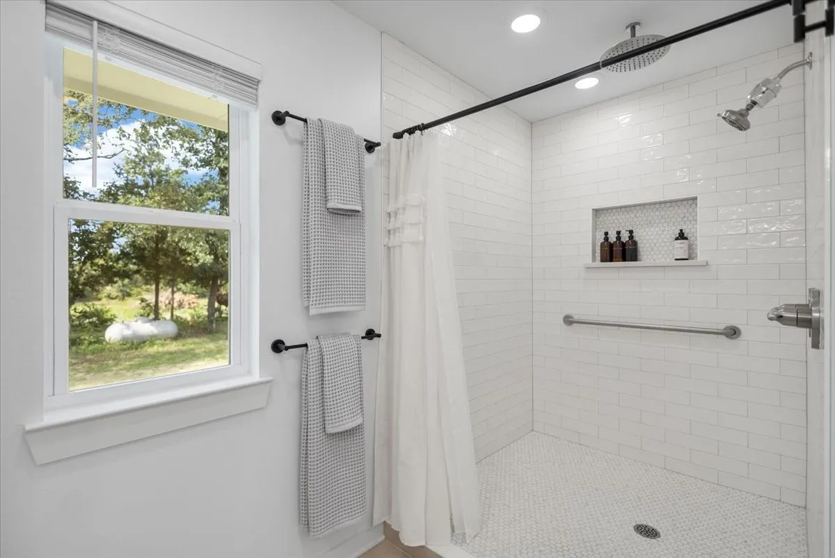 White subway tile shower in Primary En Suite with a built-in niche and hexagonal mosaic floor
