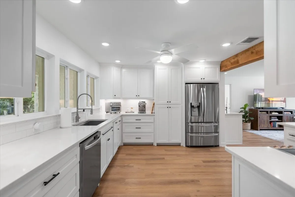Modern kitchen featuring white shaker cabinetry, stainless steel appliances, light wood-finish flooring, white countertops, and recessed lighting