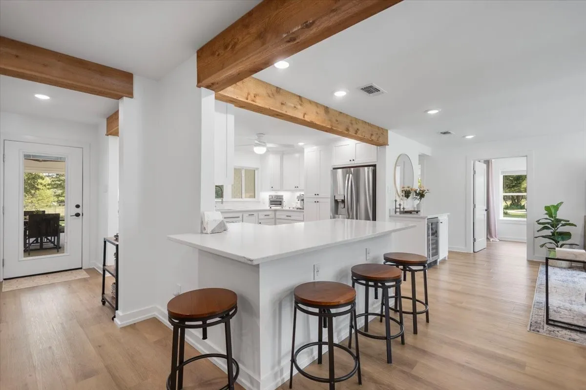 Spacious kitchen featuring white cabinetry, stainless steel appliances, with a breakfast bar