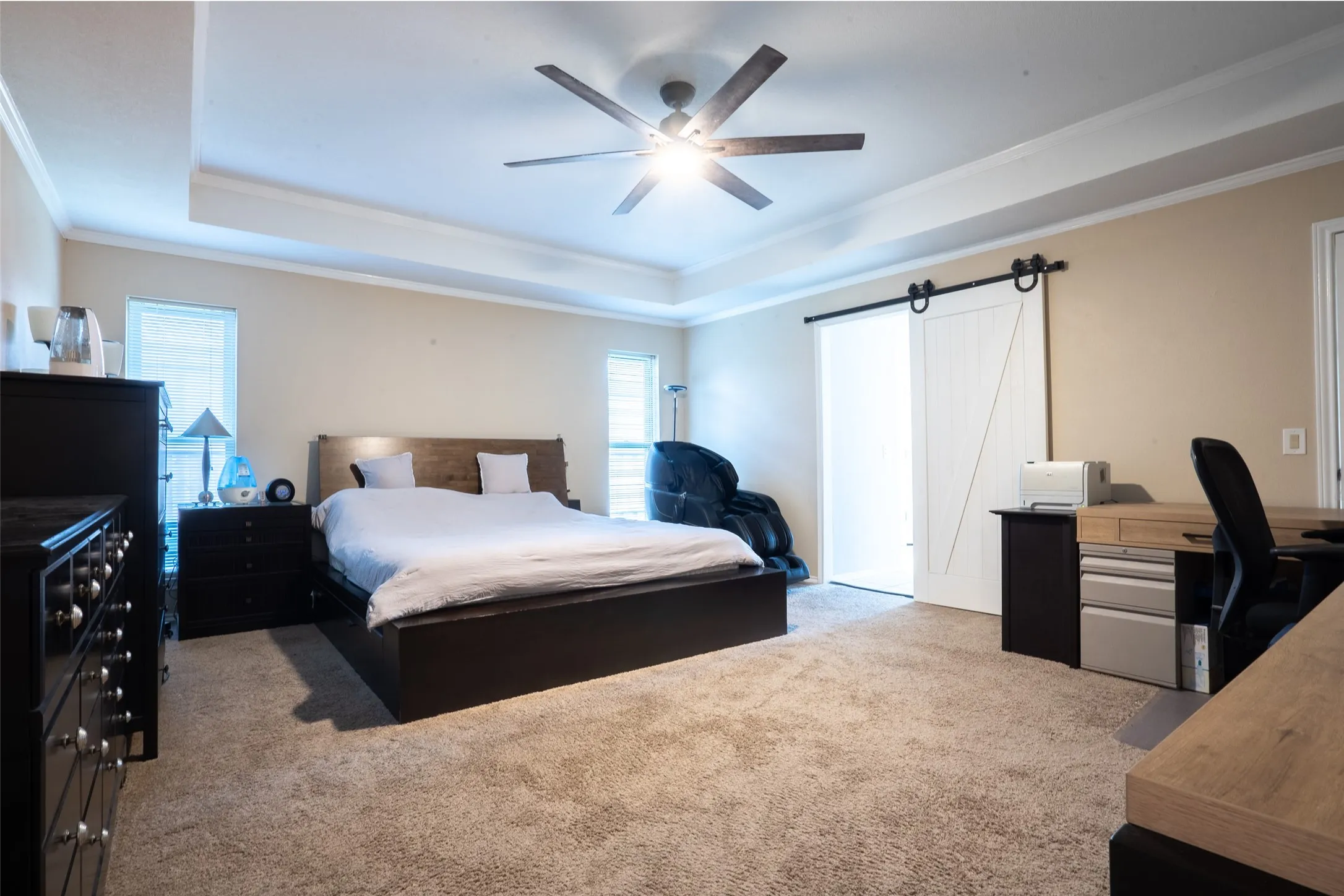 Tray ceiling with crown molding and a ceiling fan