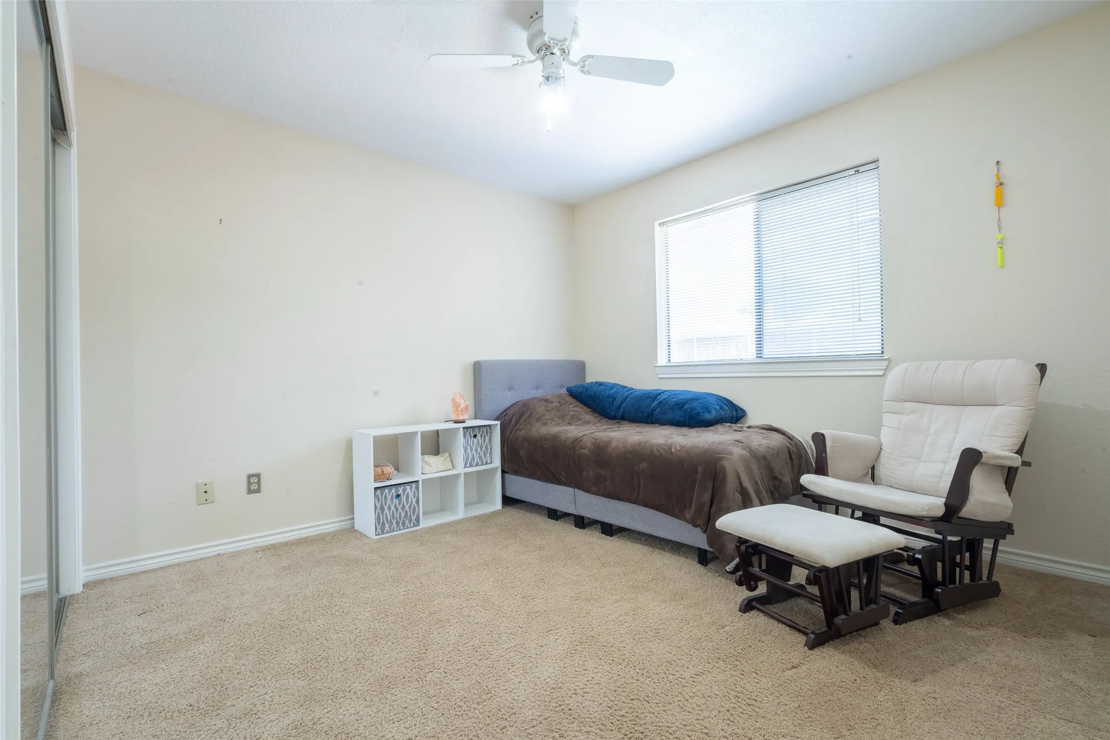 Carpeted room with a ceiling fan, a window featuring blinds, and baseboard molding