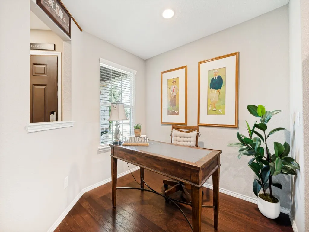 Flex space off the kitchen can be utilized as office space or a small breakfast nook. It features a bright window with blinds, and recessed lighting