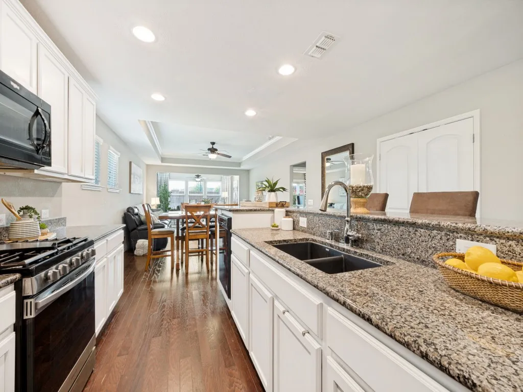 Kitchen featuring wood-finish flooring and white cabinetry