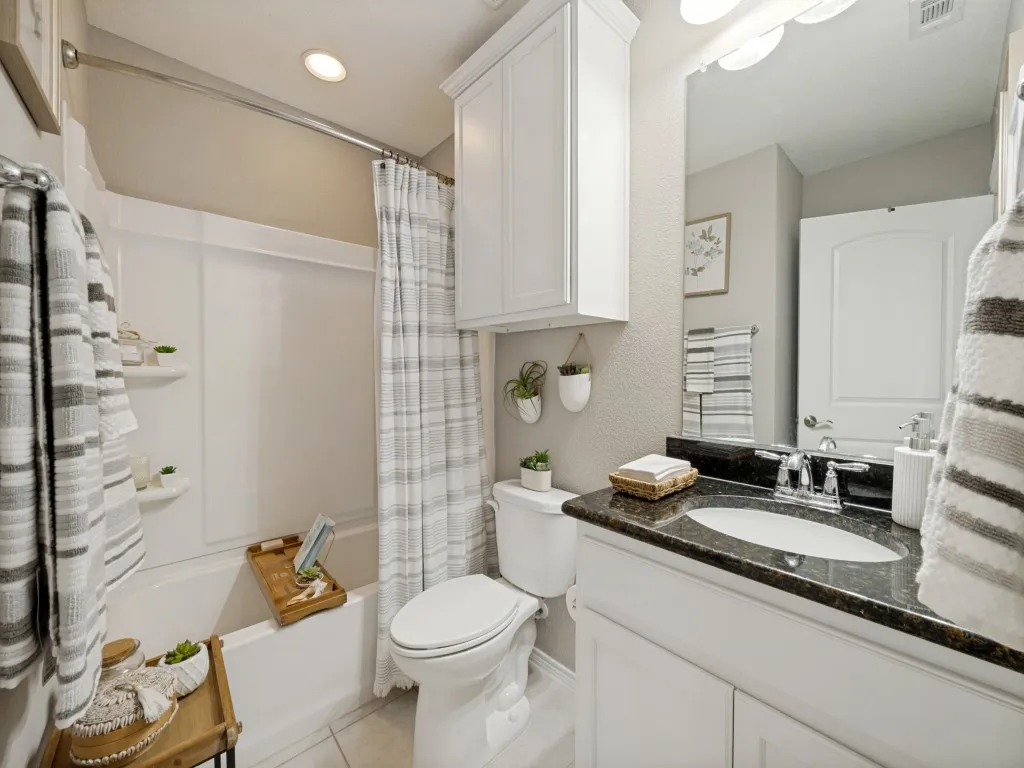 Bathroom featuring a white vanity with dark countertop and undermount sink