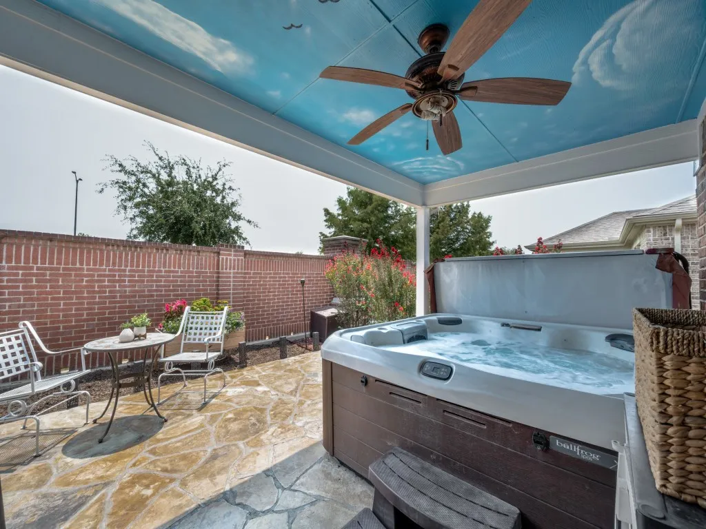 It's included!  Extended covered patio featuring a private hot tub, flagstone-style paving, and a decorative ceiling with a cloud motif