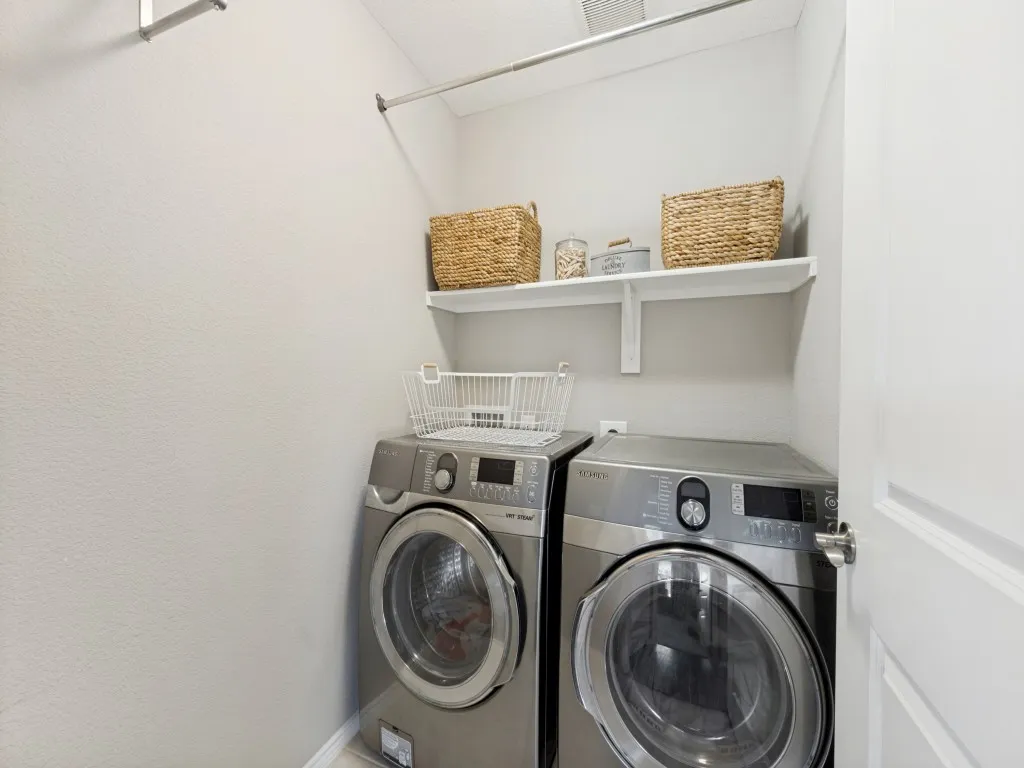 Dedicated laundry area featuring a wall-mounted shelf, hanging rod, and light-toned walls