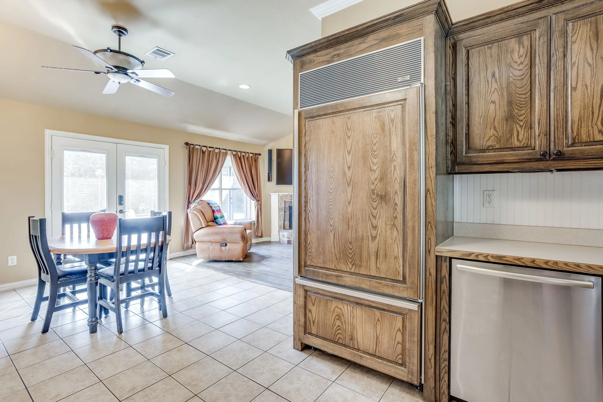 Built in SubZero Refrigerator and stainless dishwasher with a relaxing view of the pool
